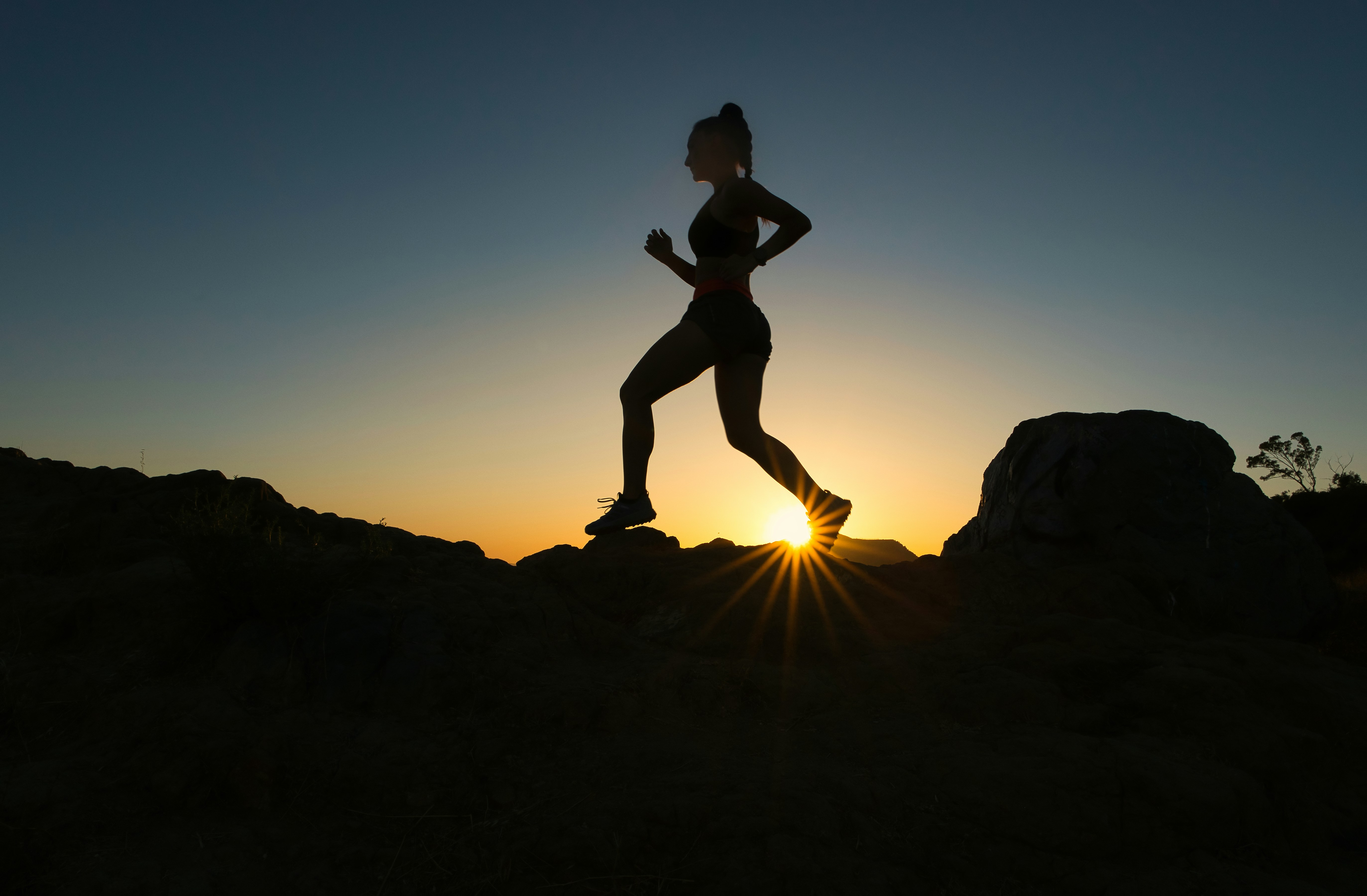 Woman running a hike at sunset