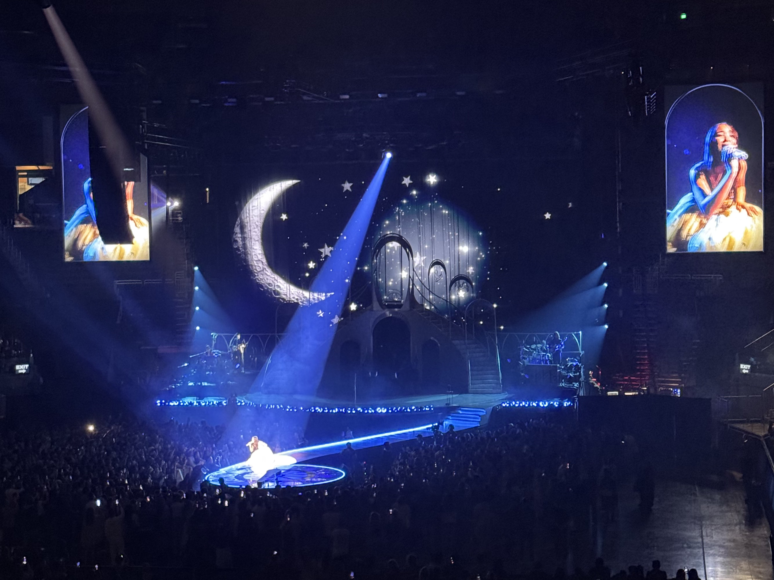 Photo of Laufey on stage with moon and stars.