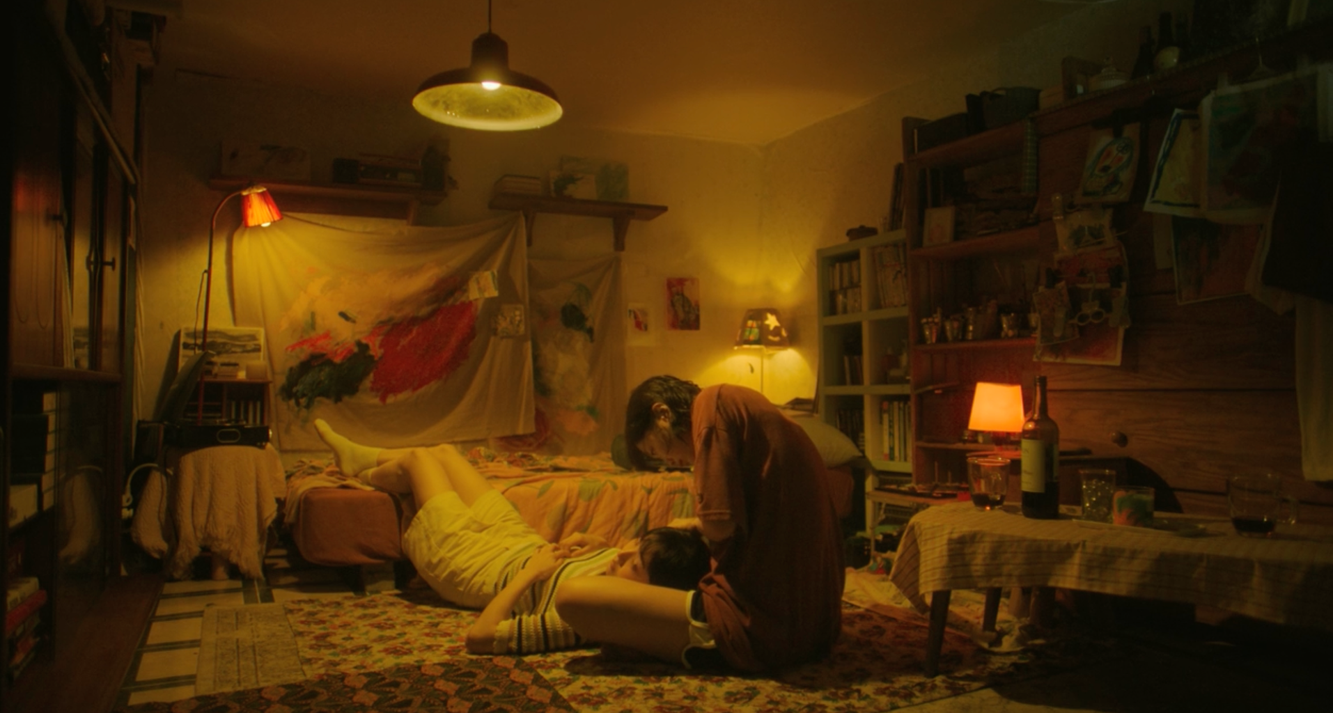 A screenshot from the film Soulmate (2023). It features actresses Kim Da-mi, who is sitting up, and Jeon So-nee, who is laying on the floor with her head in Da-mi\'s lap. They are in a warm and cozy room.