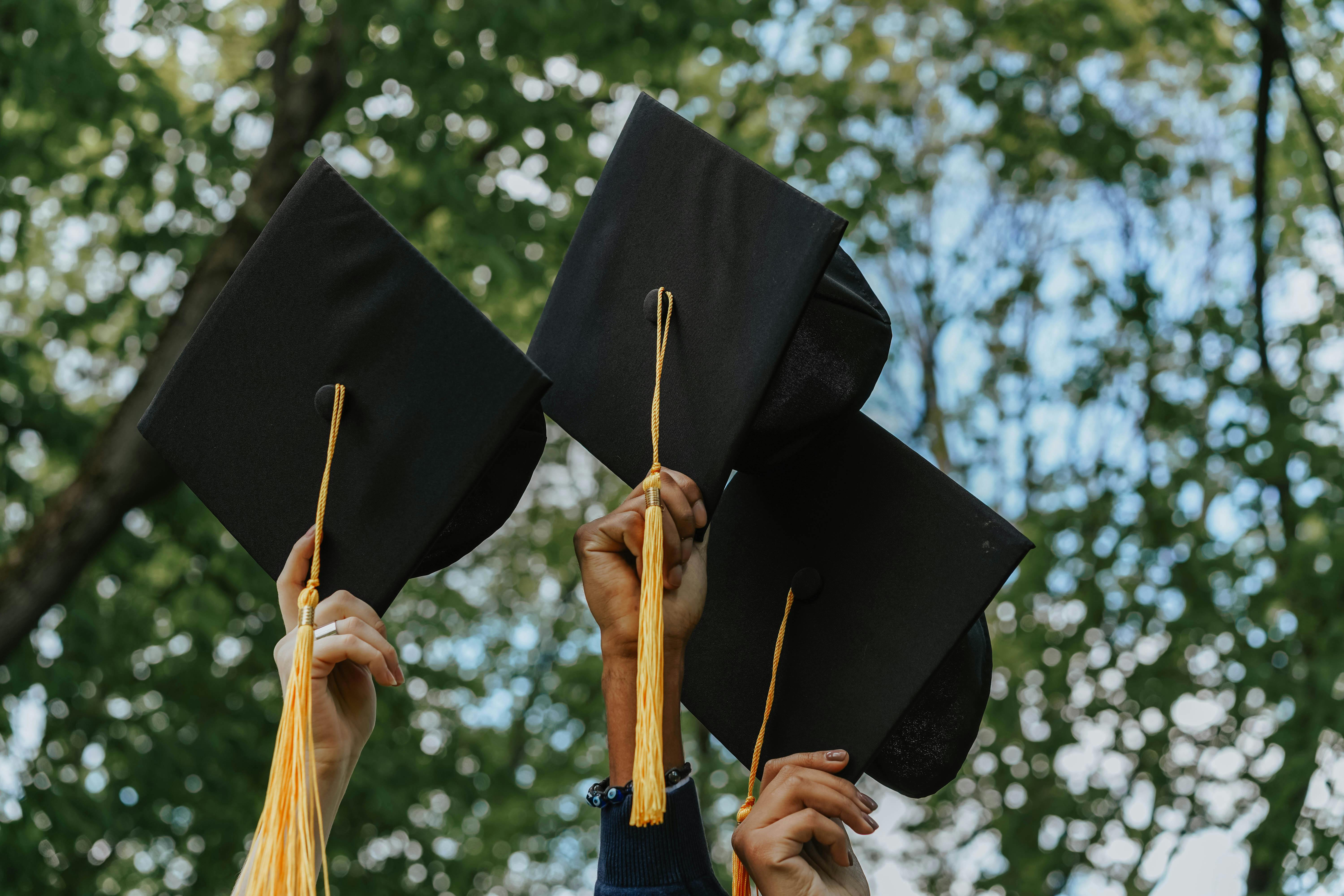 People holding graduation caps