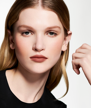 model wearing Valentino Beauty lip color in front of a white background