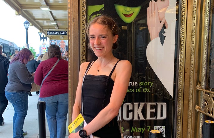 Woman in front of Wicked musical poster