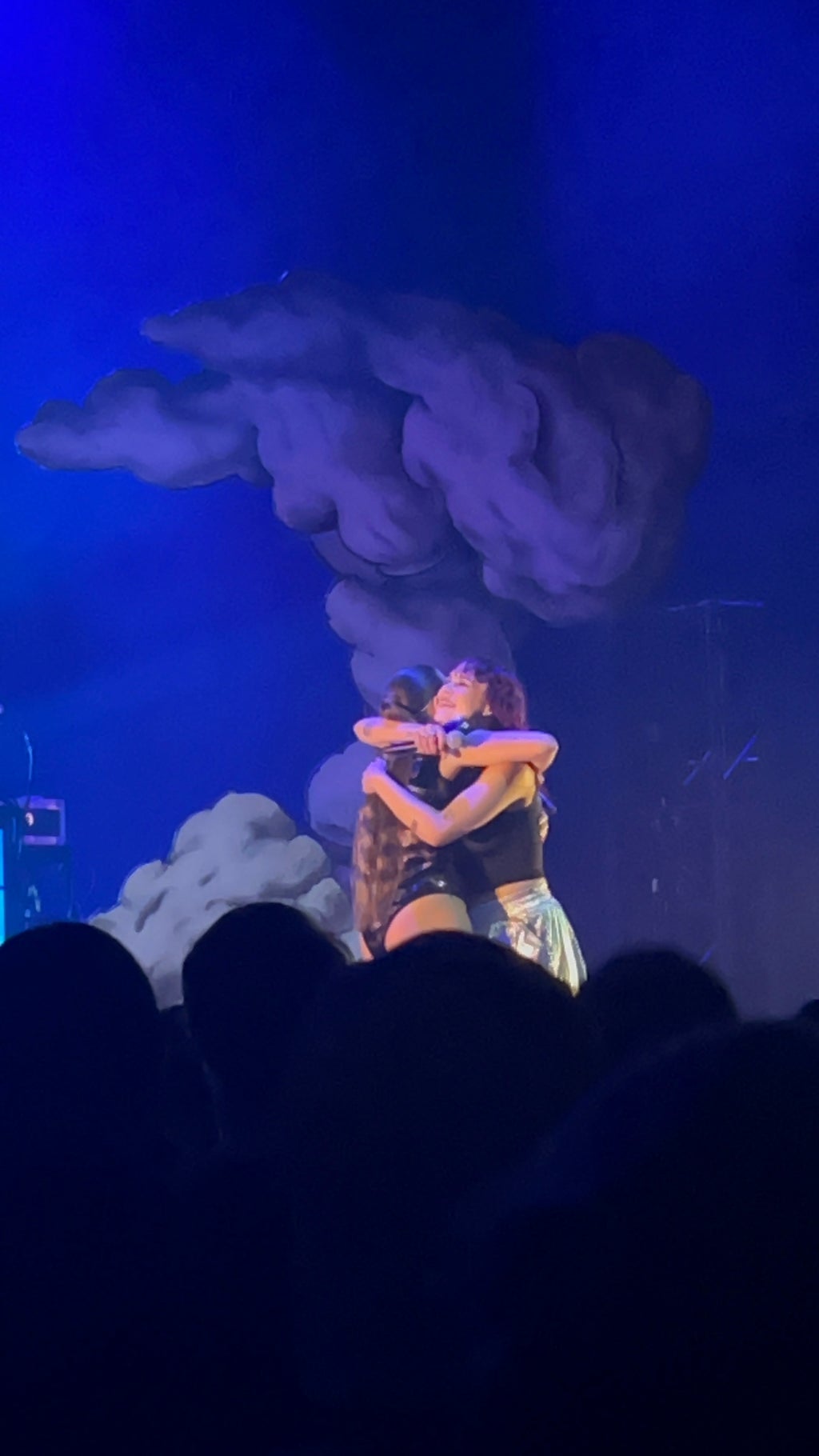 Two woman hugging on stage