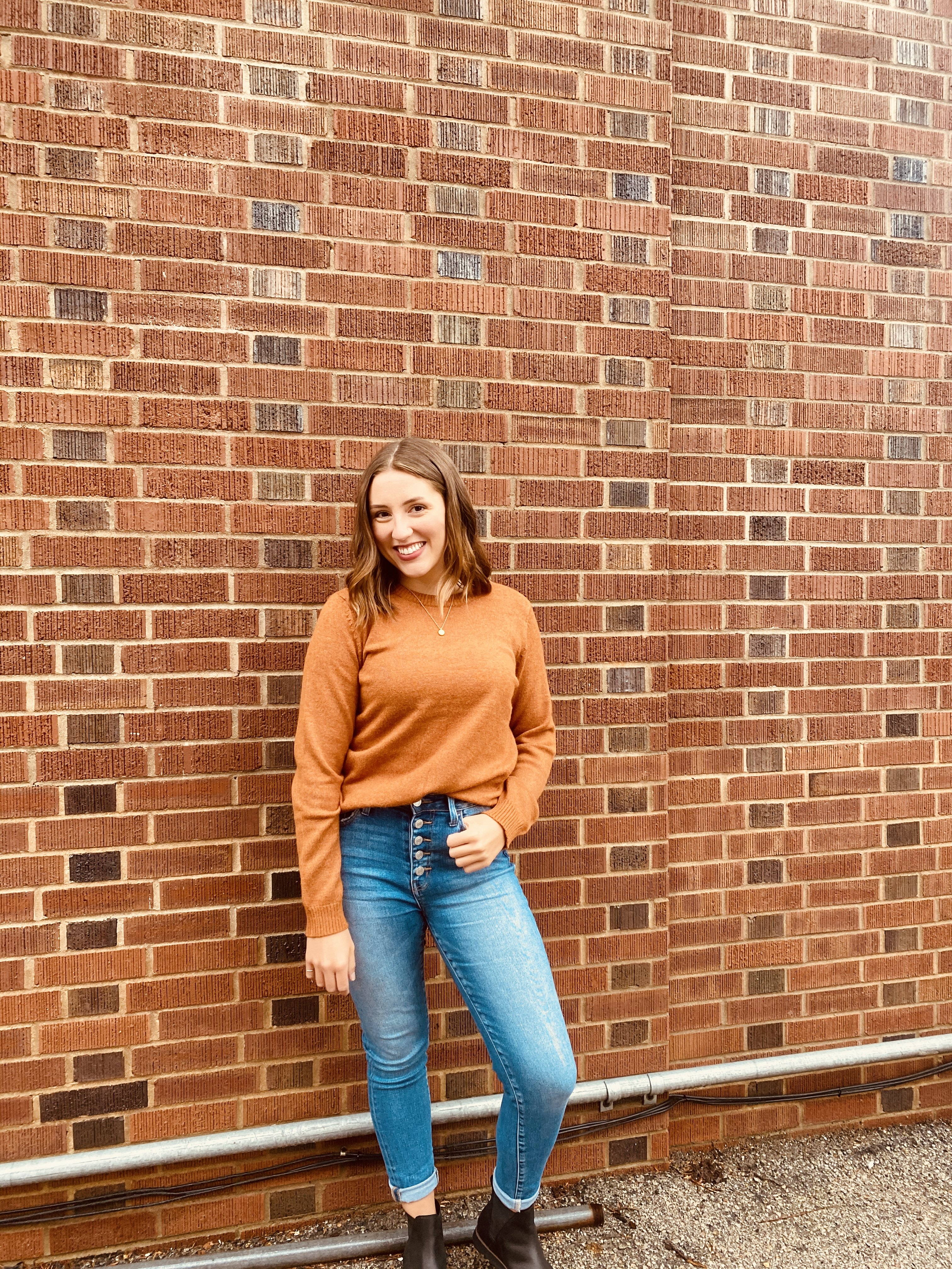 Girl posing against brick wall