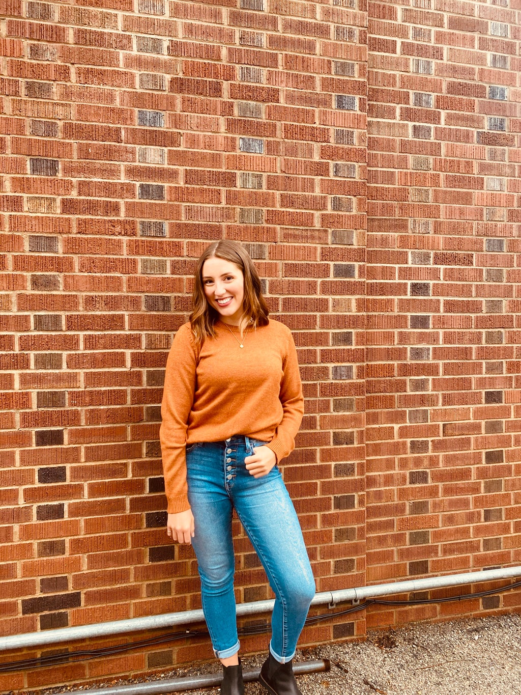 Girl posing against brick wall