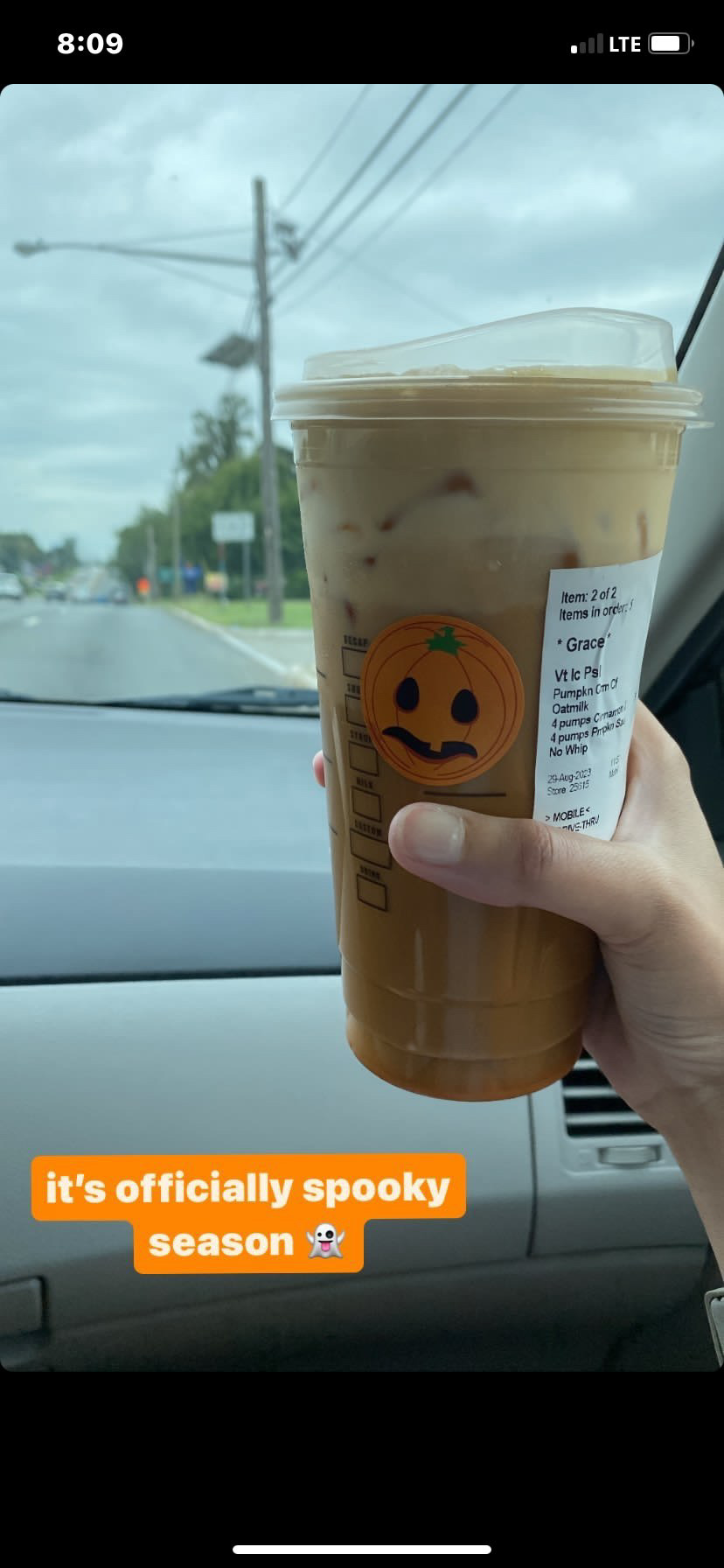 A Starbucks drink being held in a car