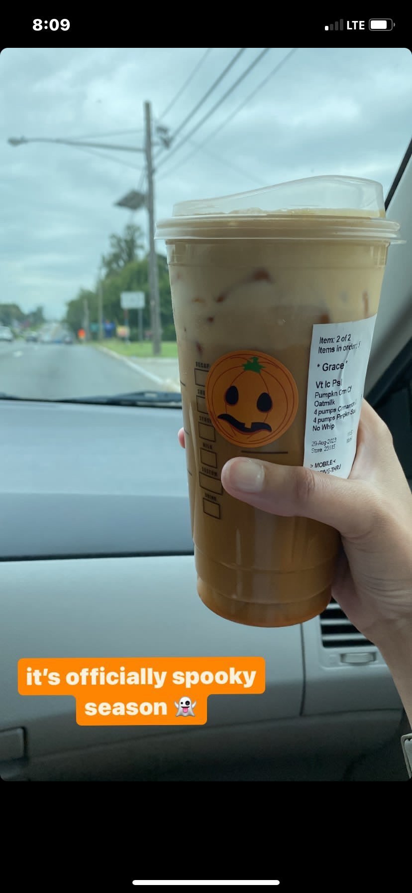 A Starbucks drink being held in a car