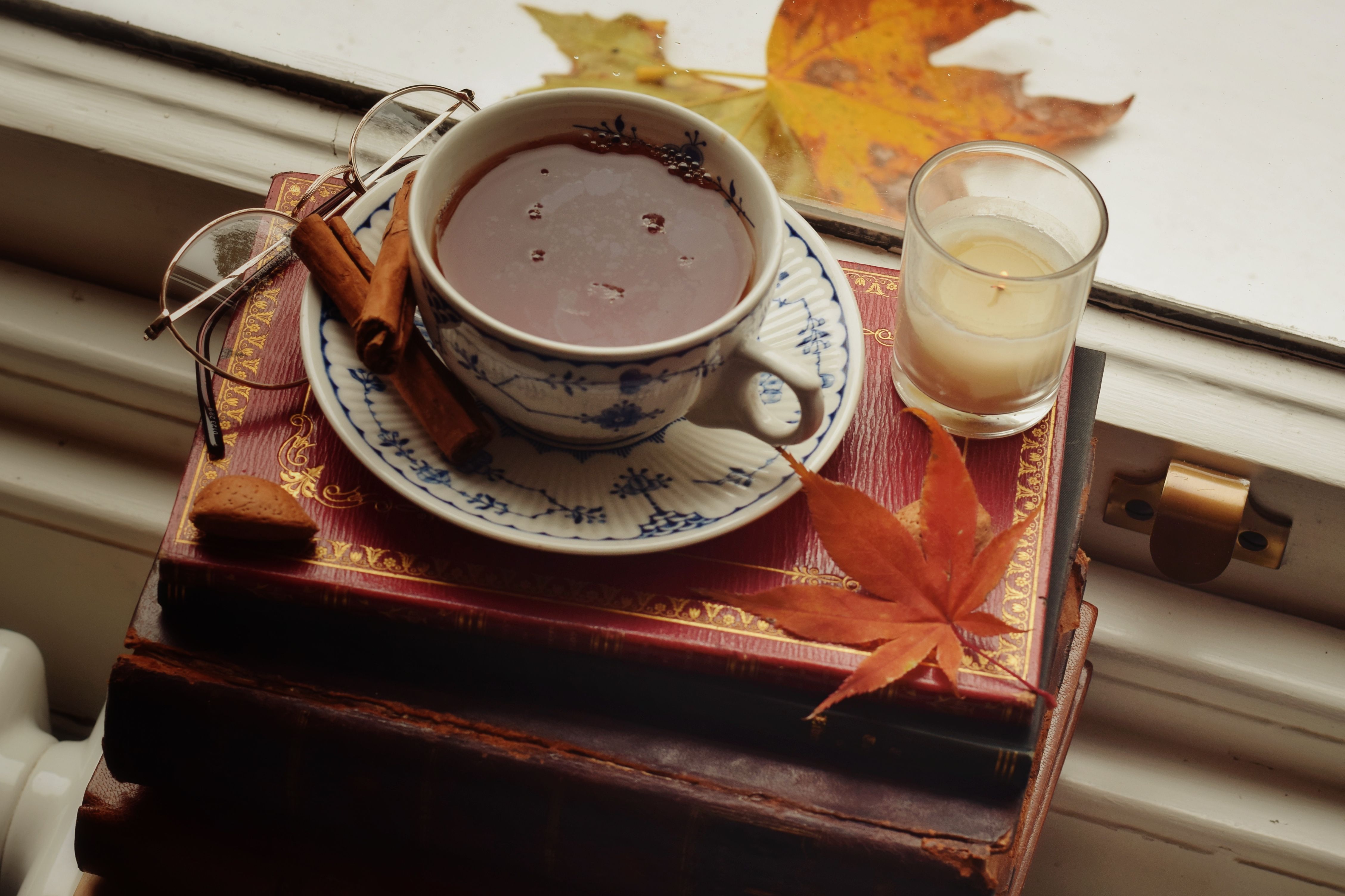 Warm autumn scene with tea and cinnamon on a window sill, perfect for cozy moments