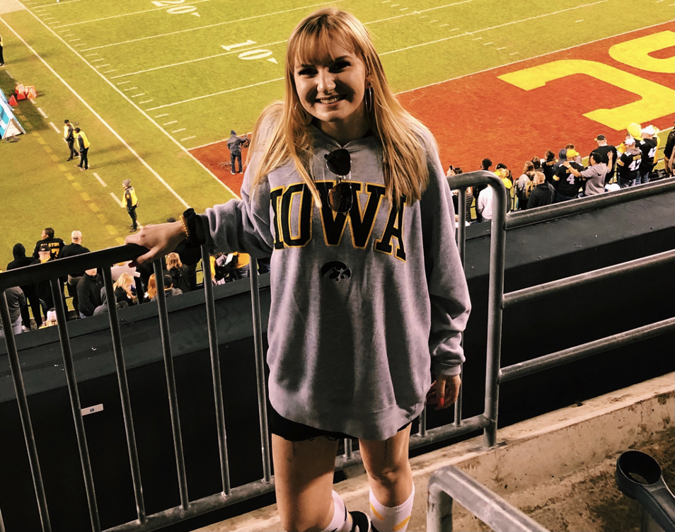 girl standing in the bleachers at a football game