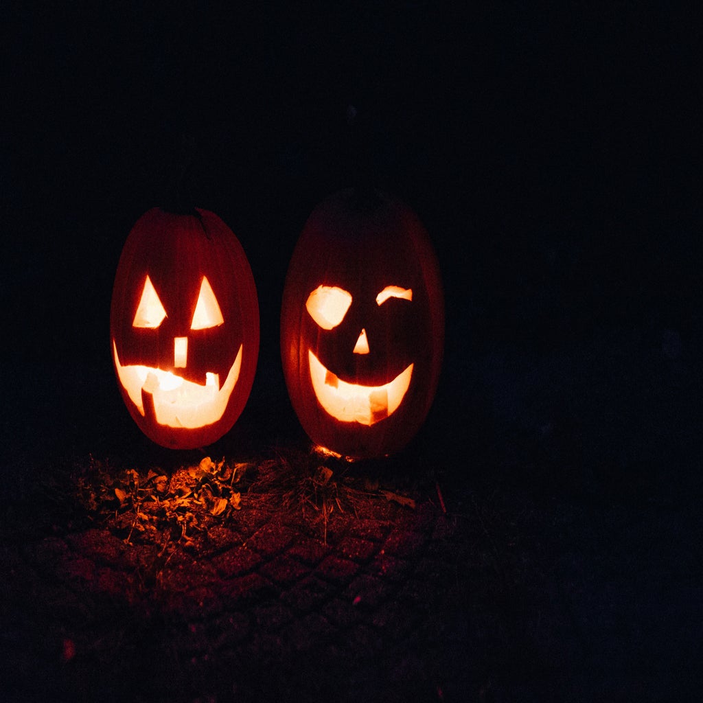 two pumpkins with faces carved in them