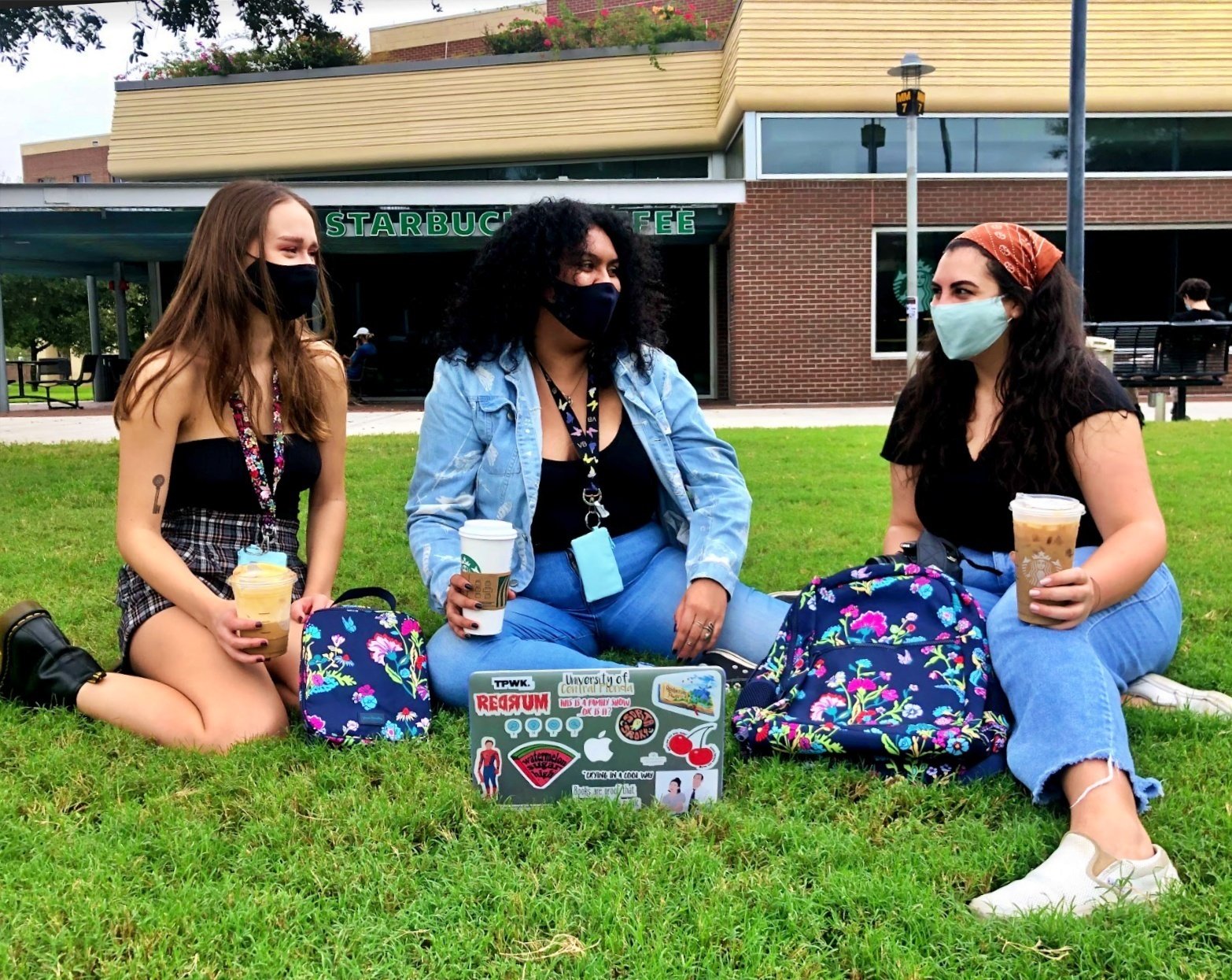 three students sitting and talking with coffee