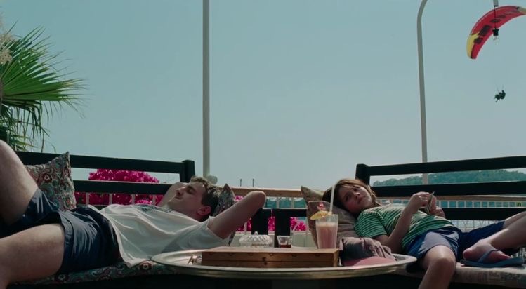 Father and daughter laying on couches outside.