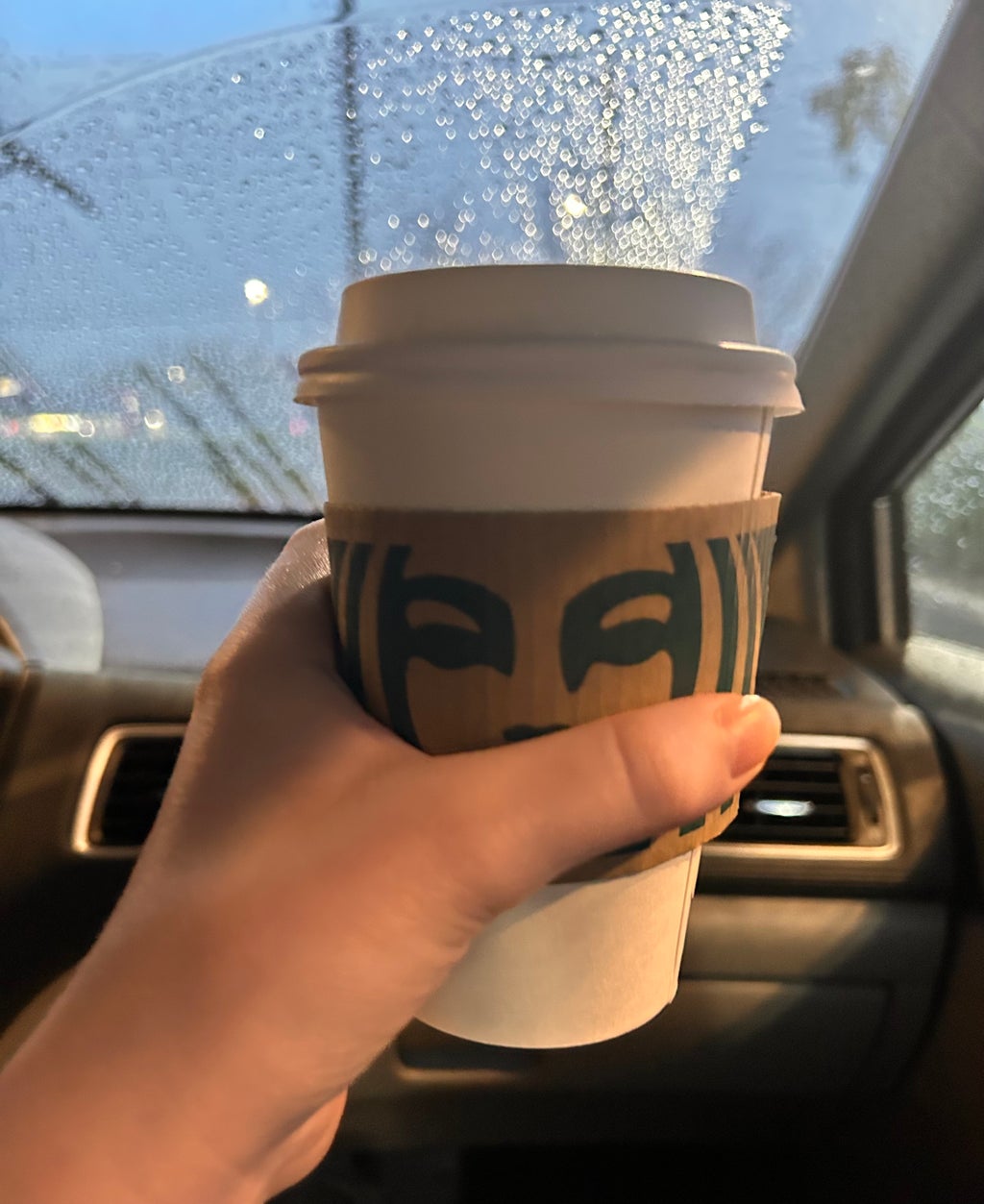 Holding Starbucks Cup in Car