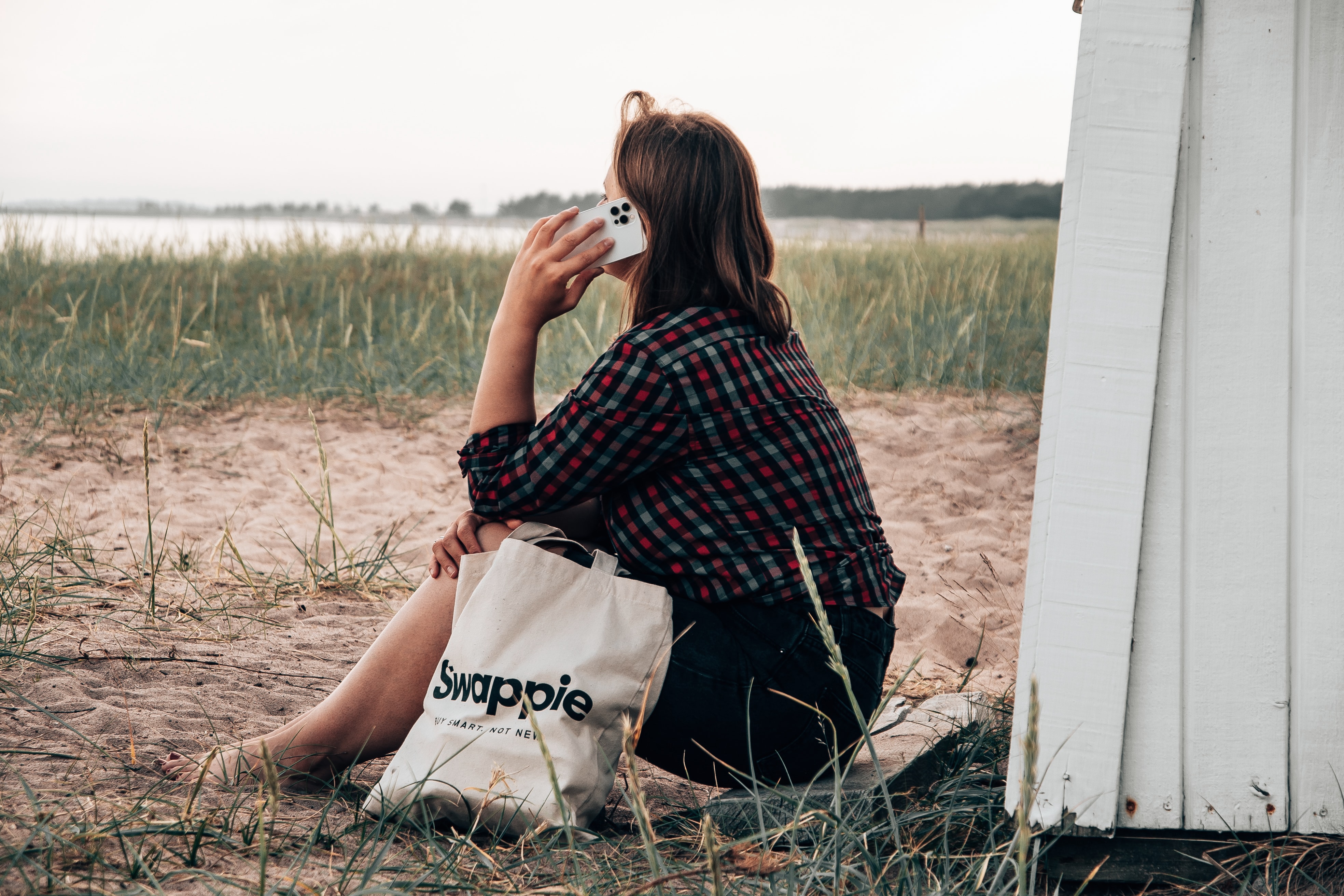 woman with phone to her ear sitting outside