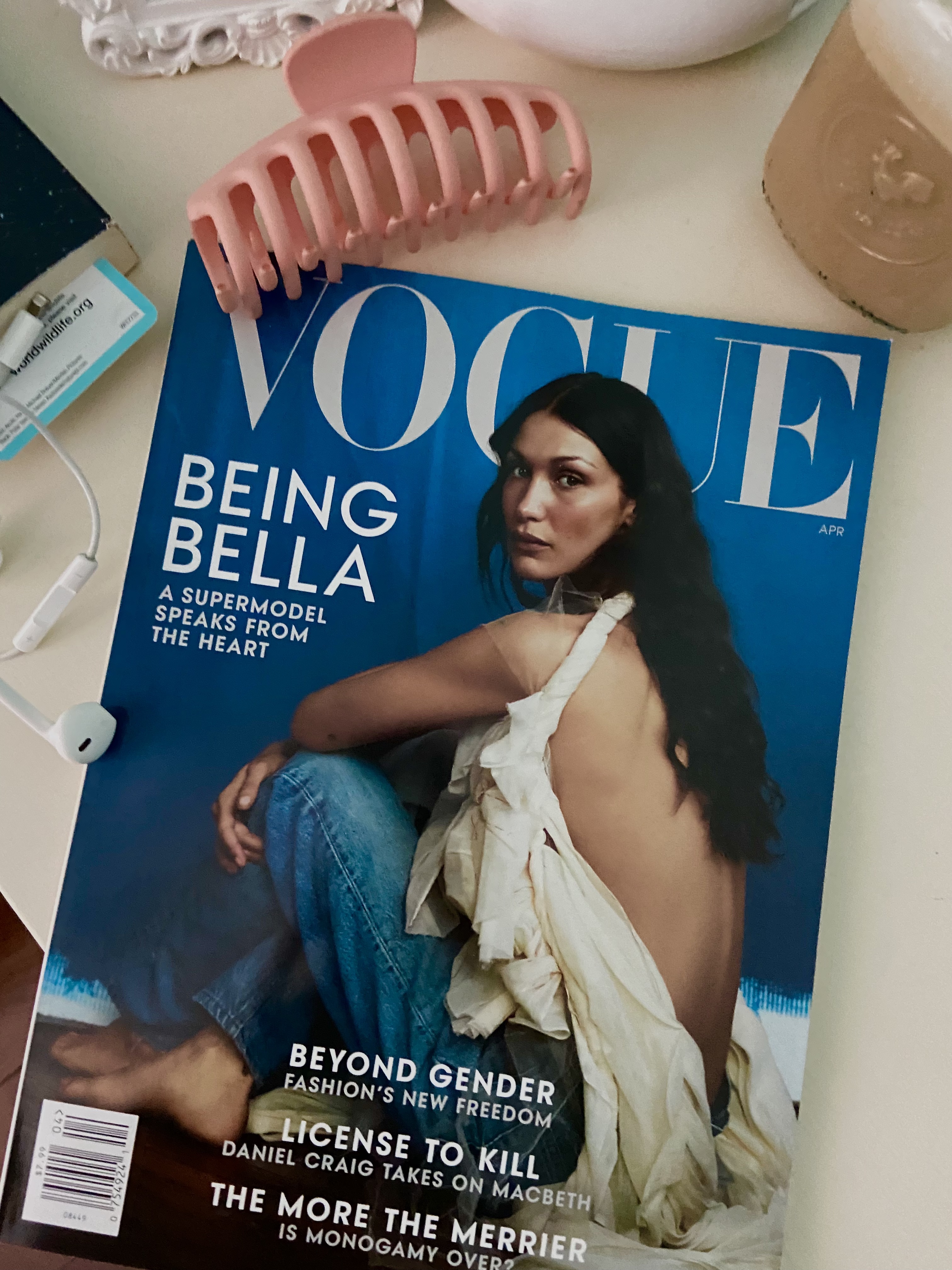 Vogue magazine on desk with coffee beside it.