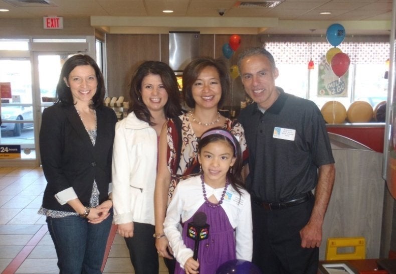 Darya in front of family members in McDonalds speaking for Ronald McDonald Foundation post-recovery