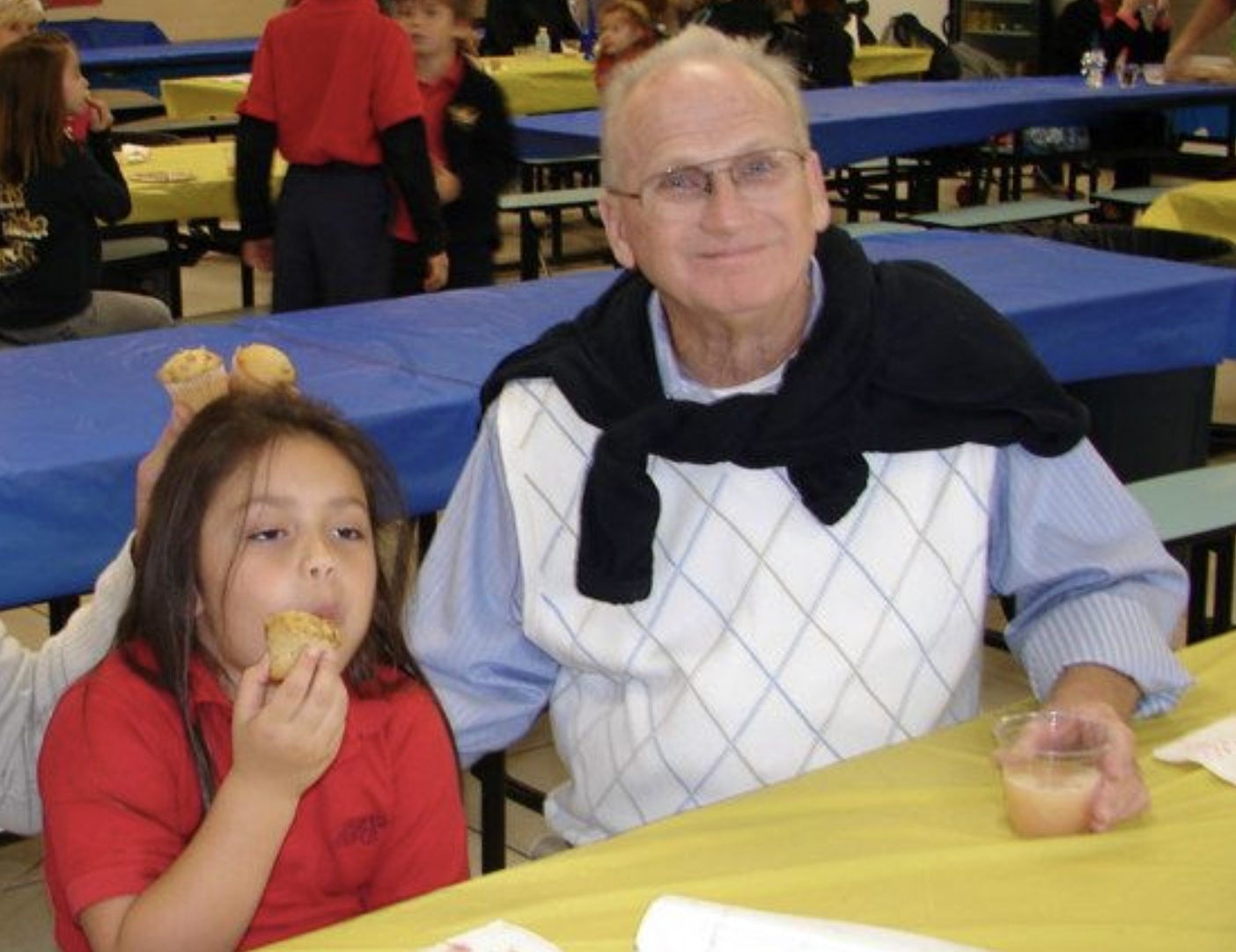 girl and grandfather sitting at table