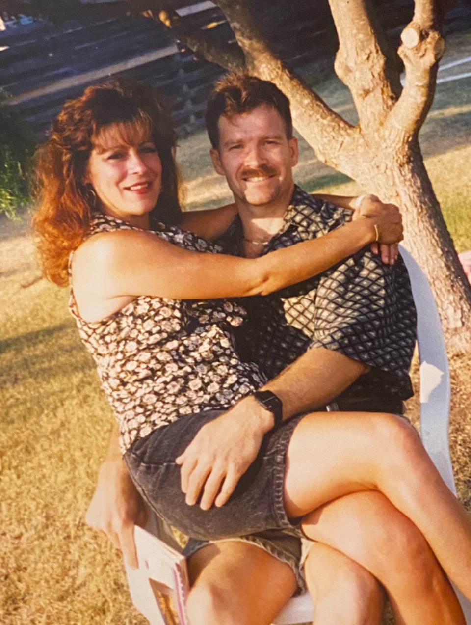 my gg (wife) sitting on my poppa\'s (husband) lap in the yard