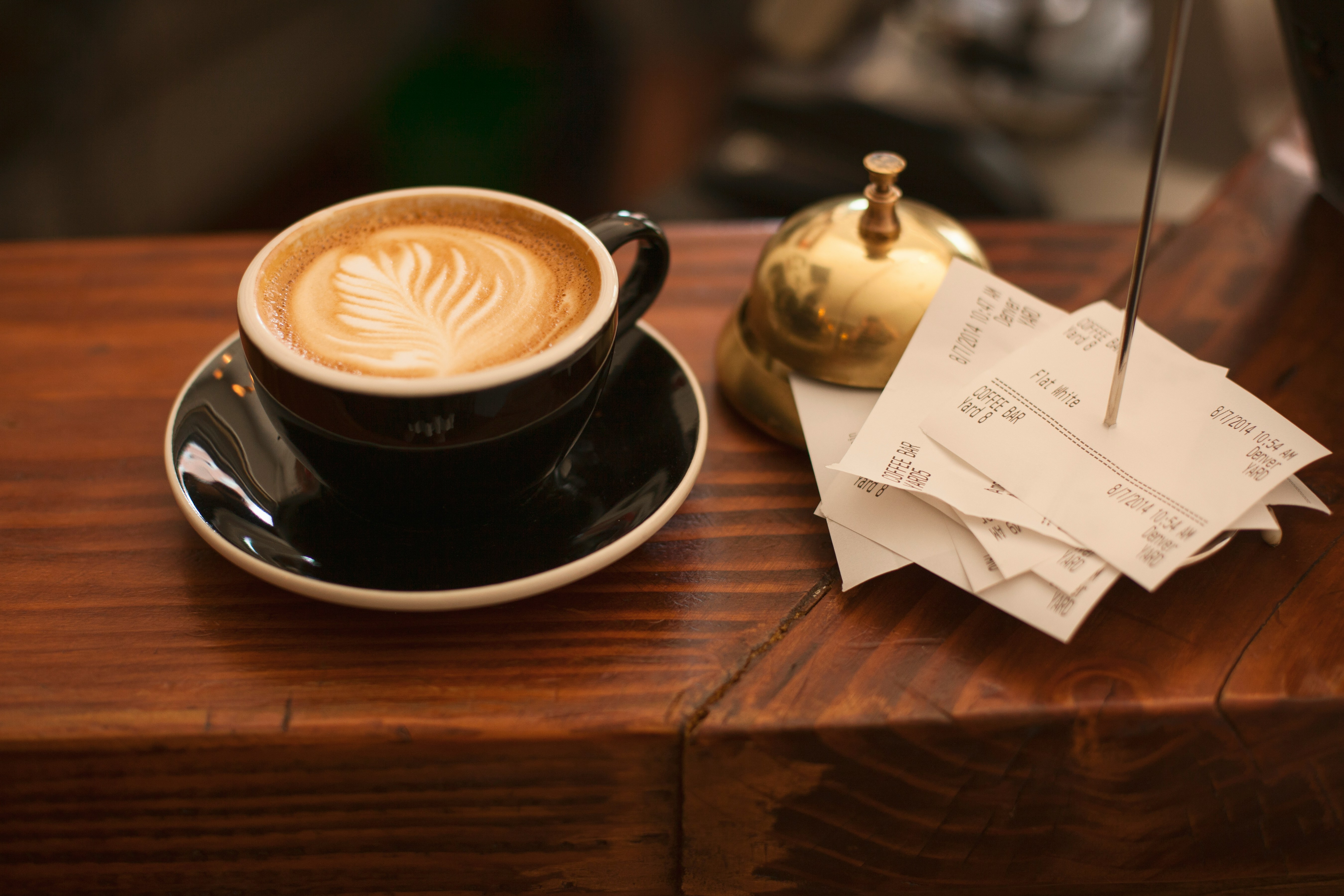 Black cappuccino mug next to receipts