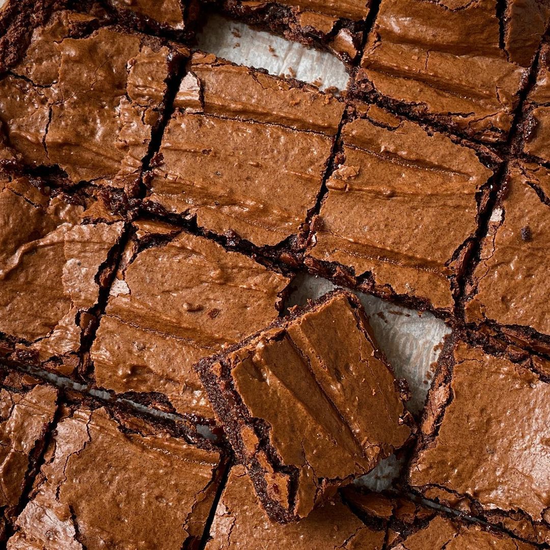 grid of brownies with one laying on top