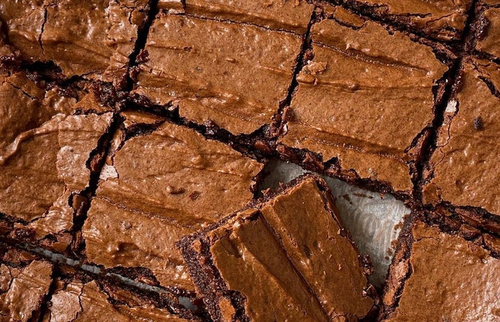 grid of brownies with one laying on top