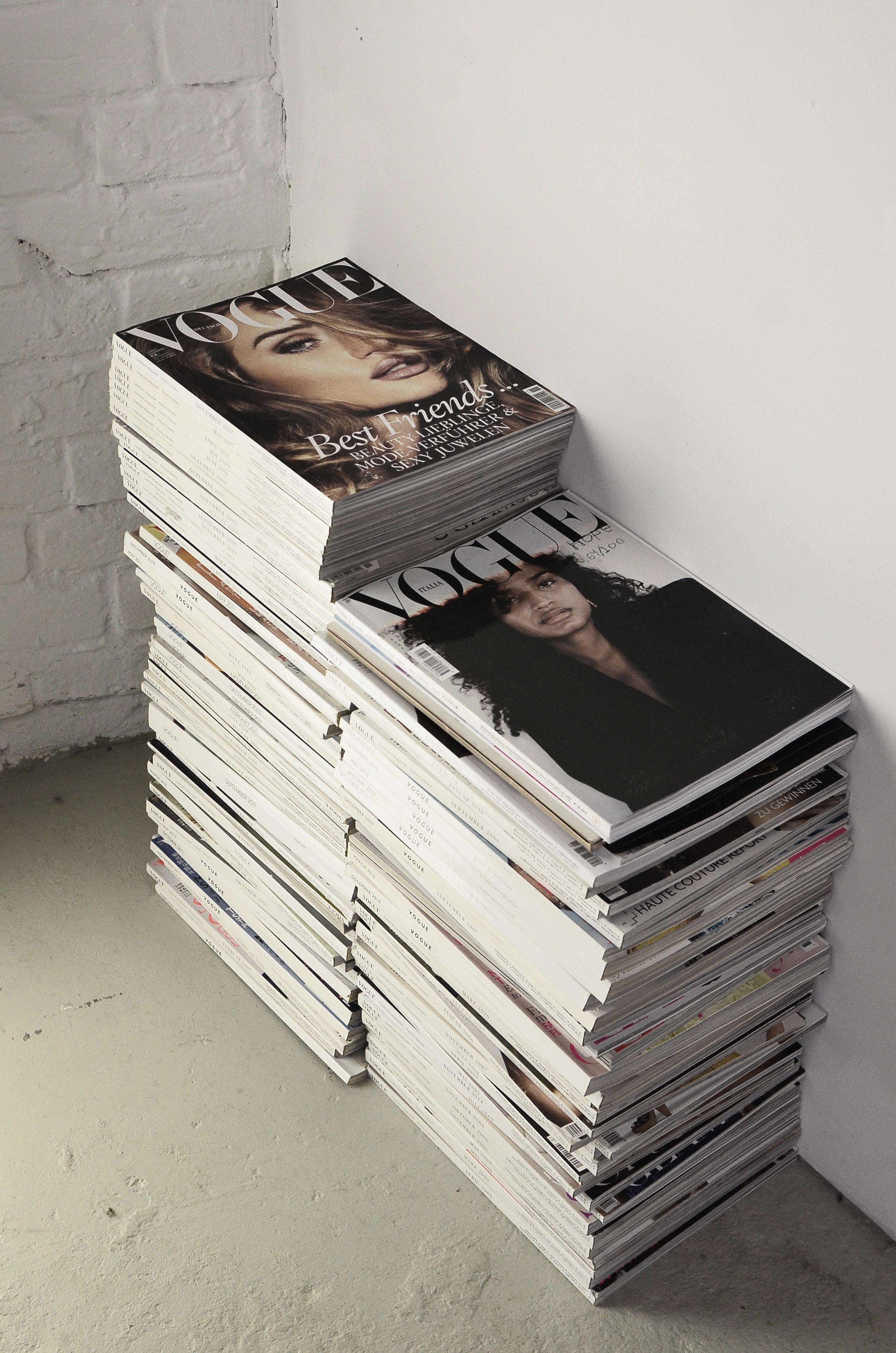 Stack of fashion magazines on floor