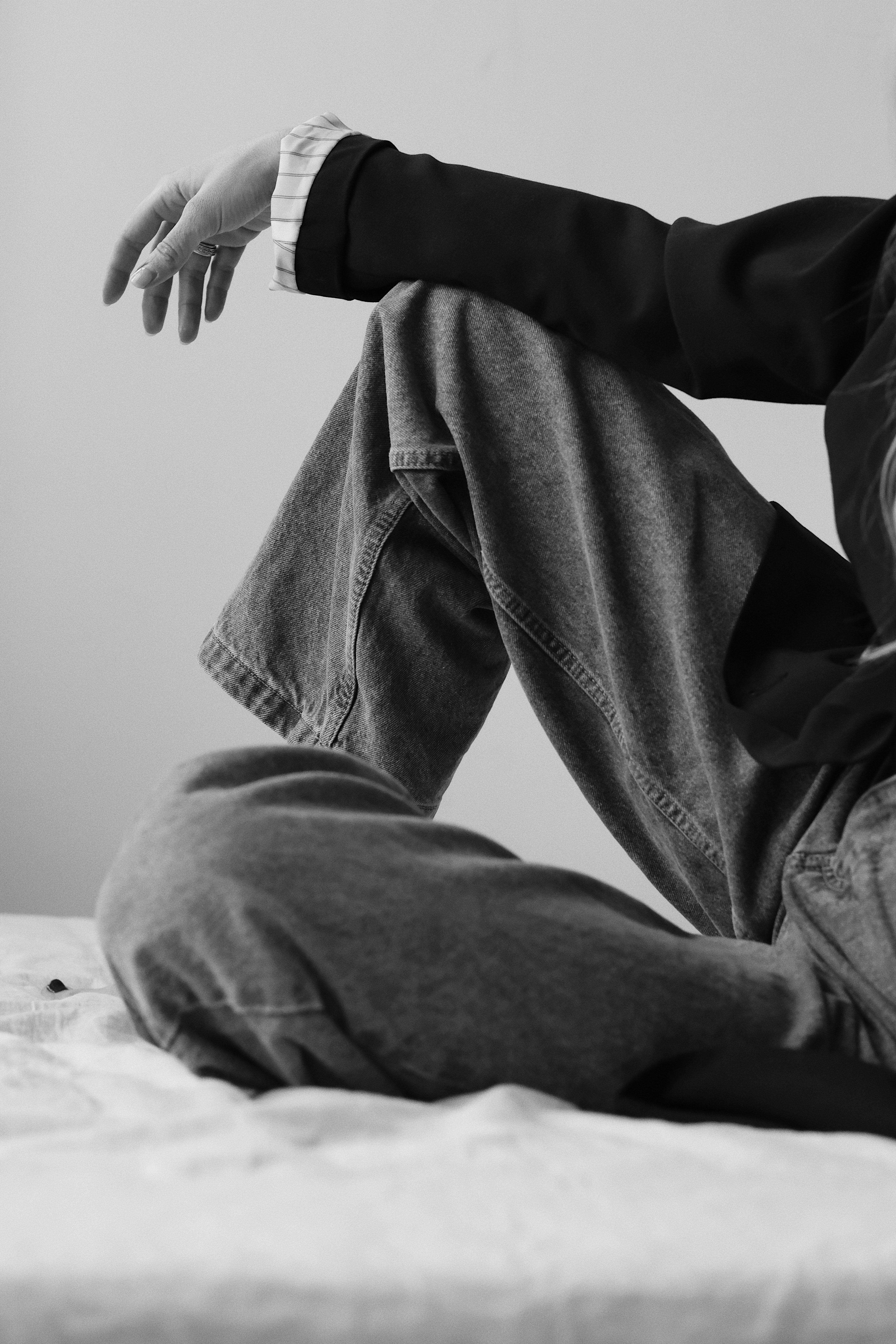 Person sitting on bed, legs crossed