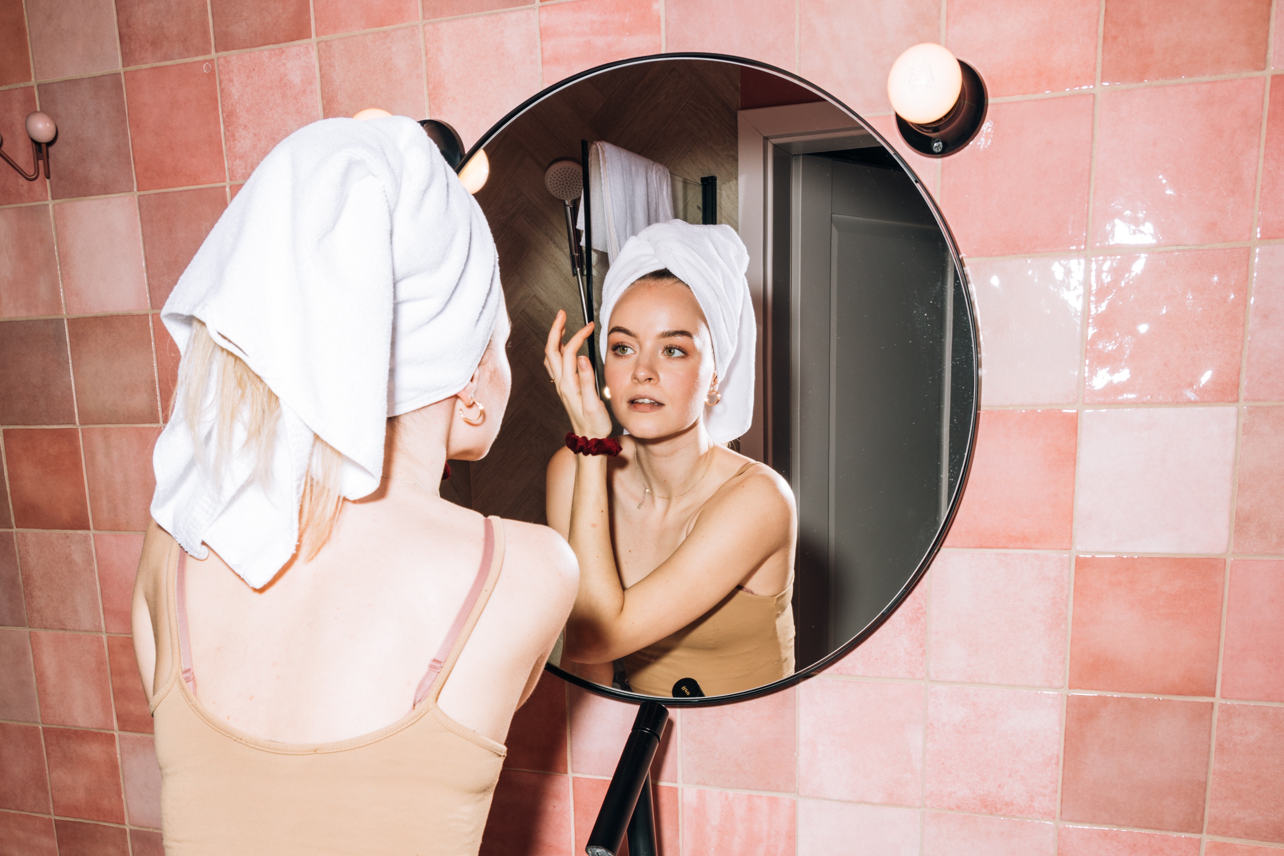 Woman in front of mirror doing skincare
