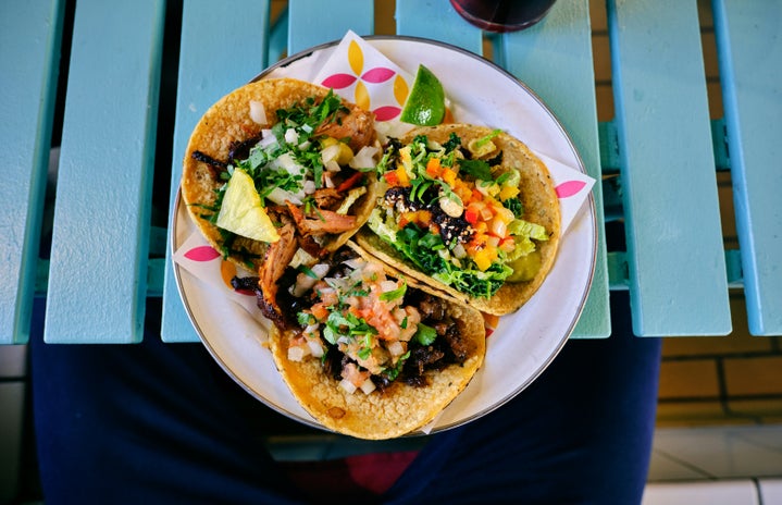 Three tacos placed on a blue table