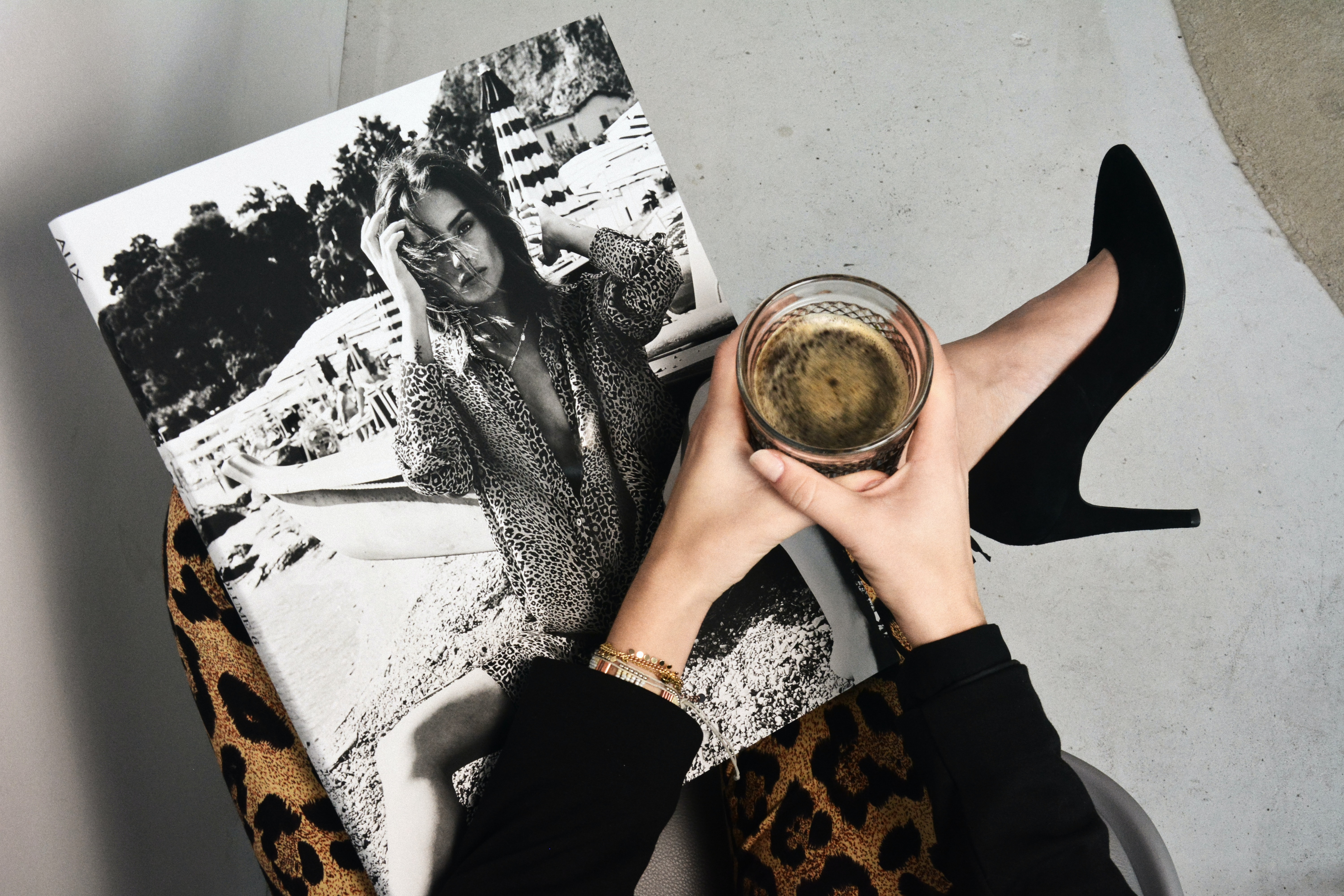 Woman in black high heels holding glass candle and black-and-white portrait of model