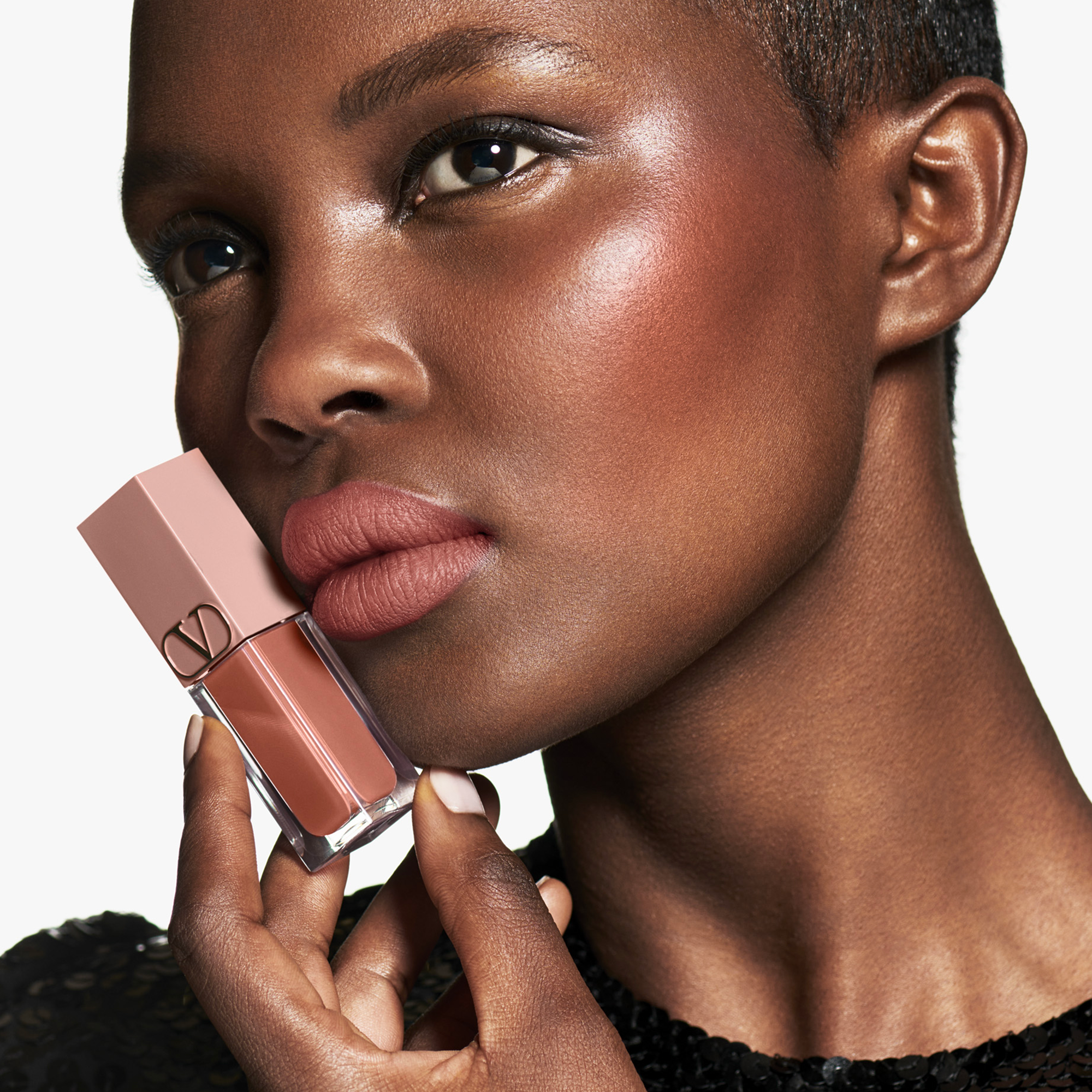 model wearing Valentino Beauty lip color in front of a white background