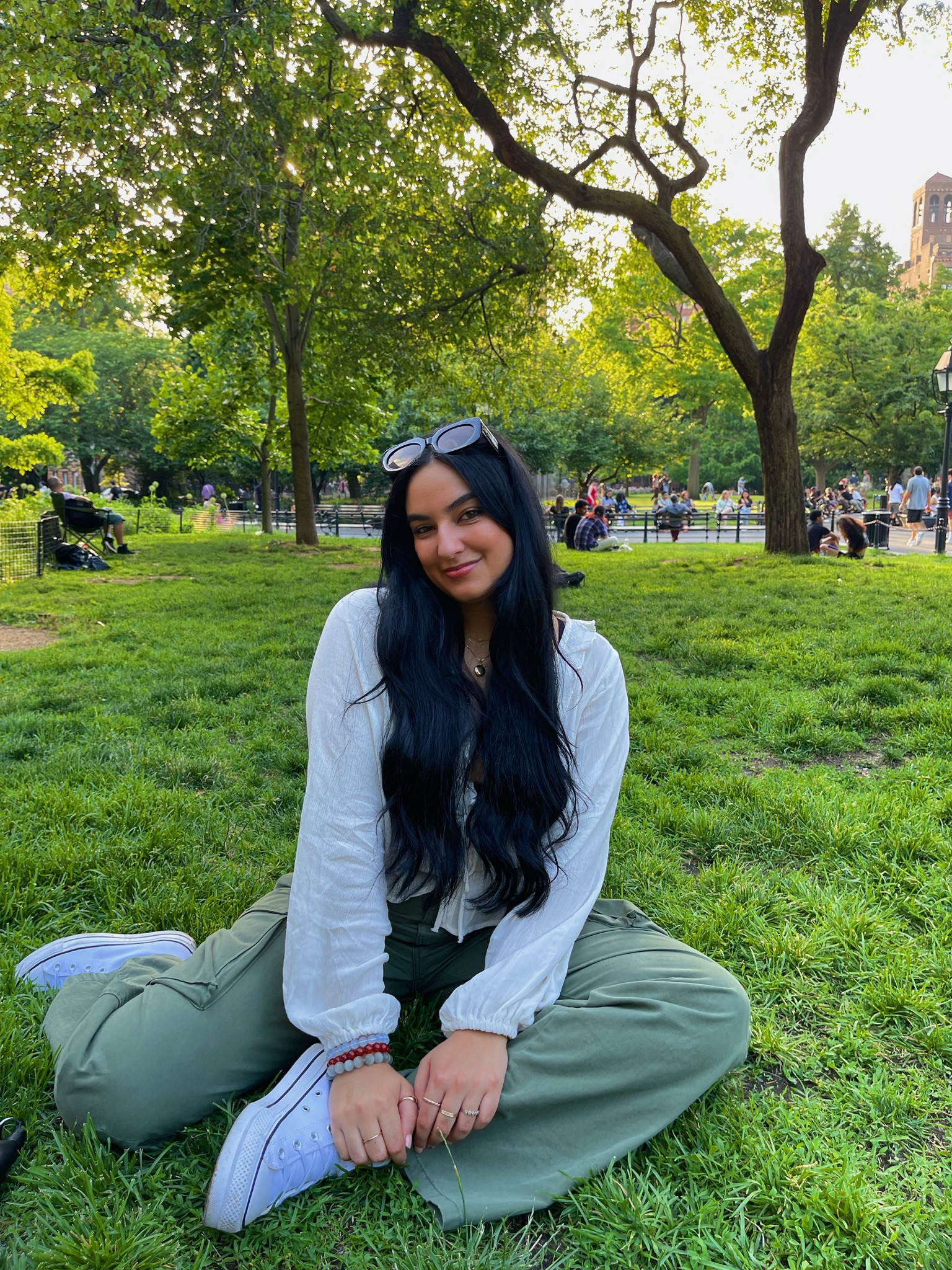Safaa Salem sitting on grass with green pants and a white top