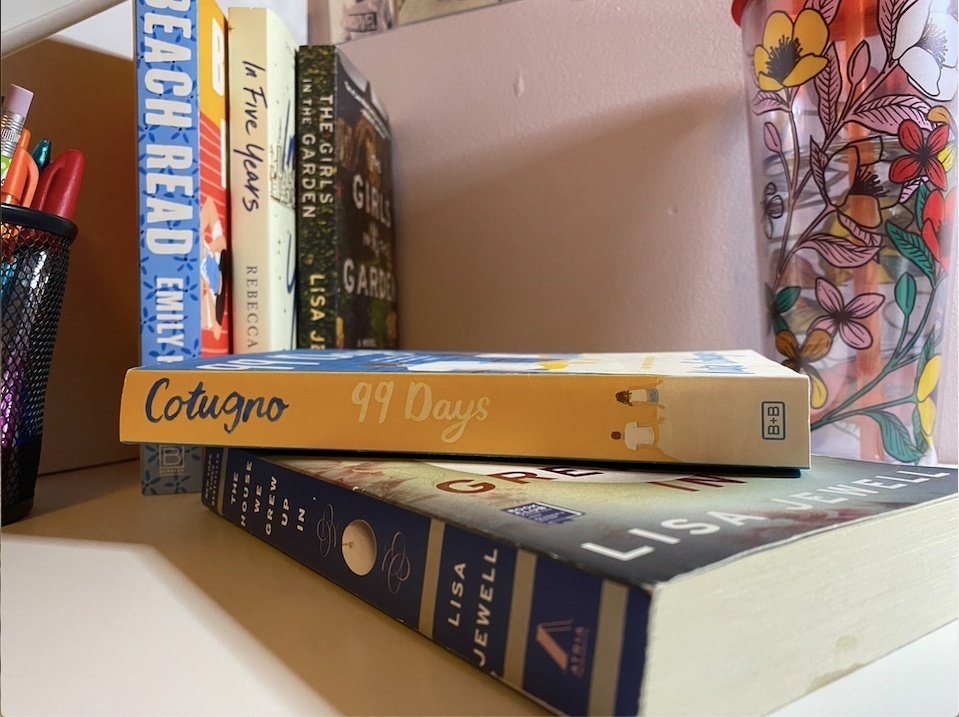 five books sitting on a desk with a water bottle in the background