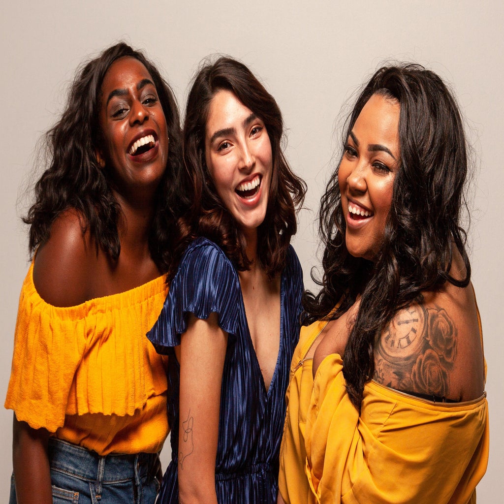 Three women laughing at the camera