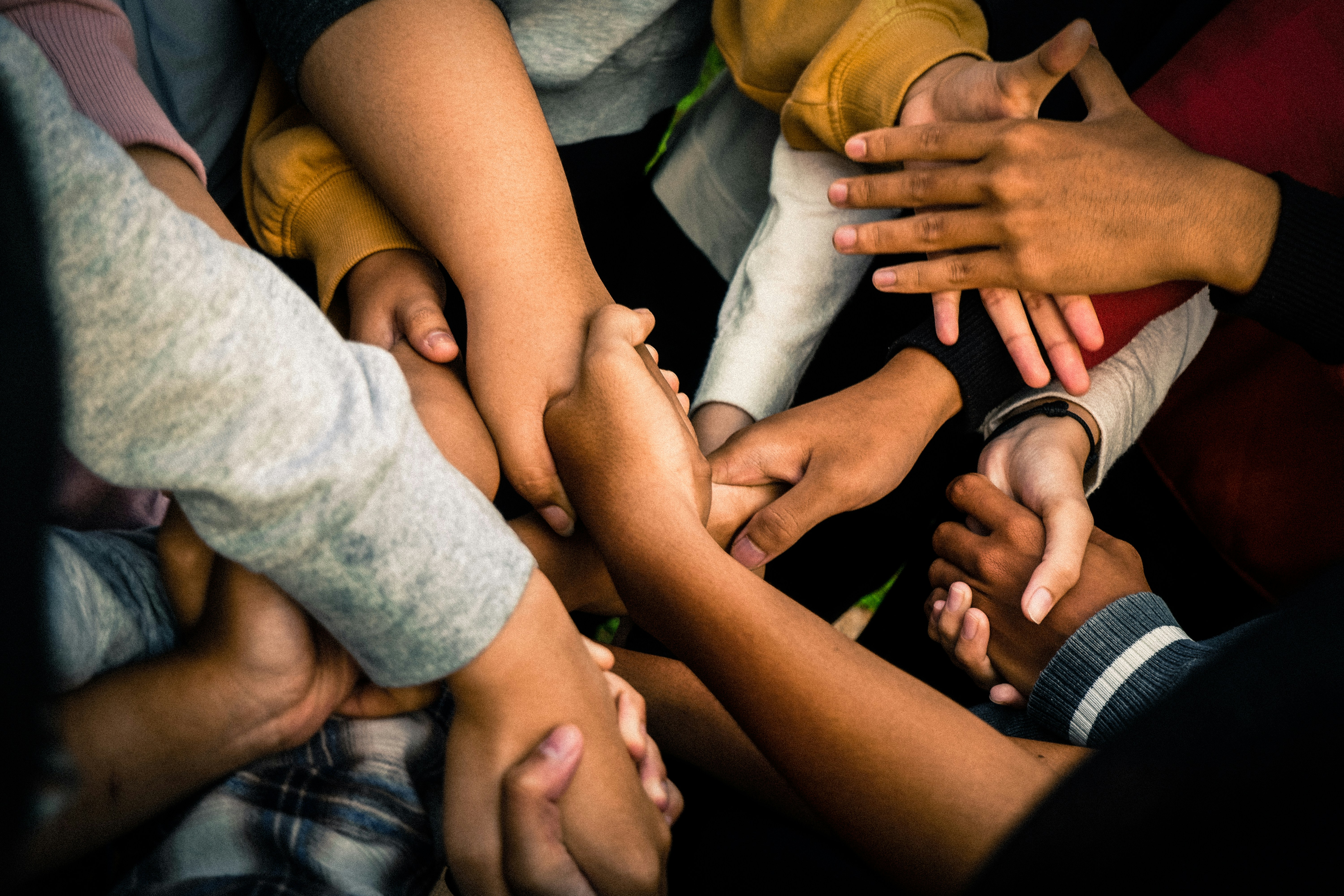 A close up shot of  bunch of people holding hands