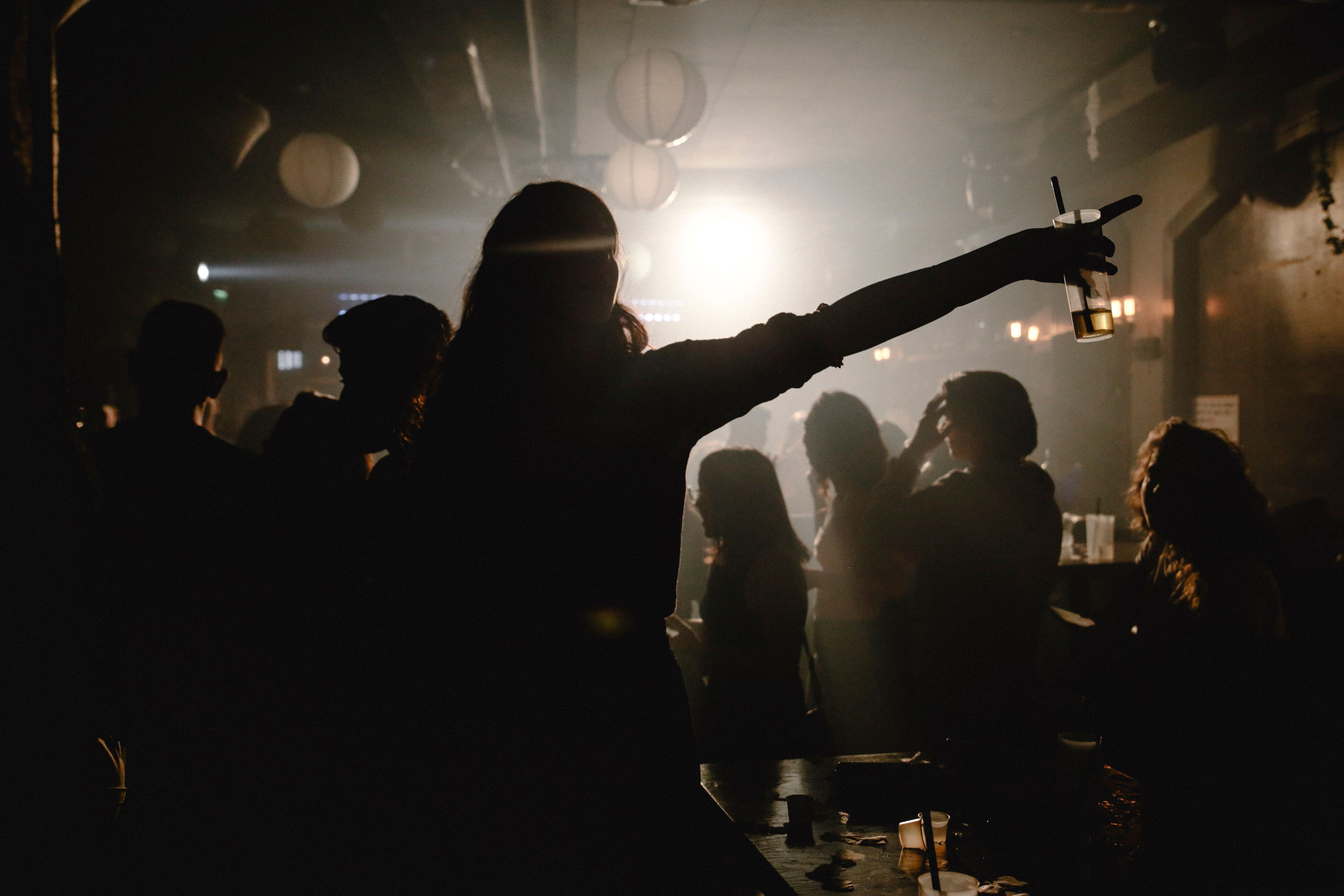 a low-light room with people silhouettes as the focus