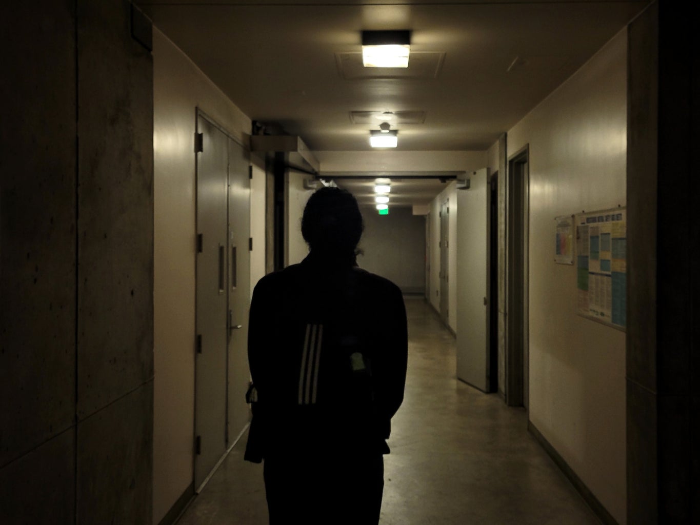 person standing in dark hallway
