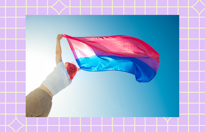 woman holding up a bisexual pride flag