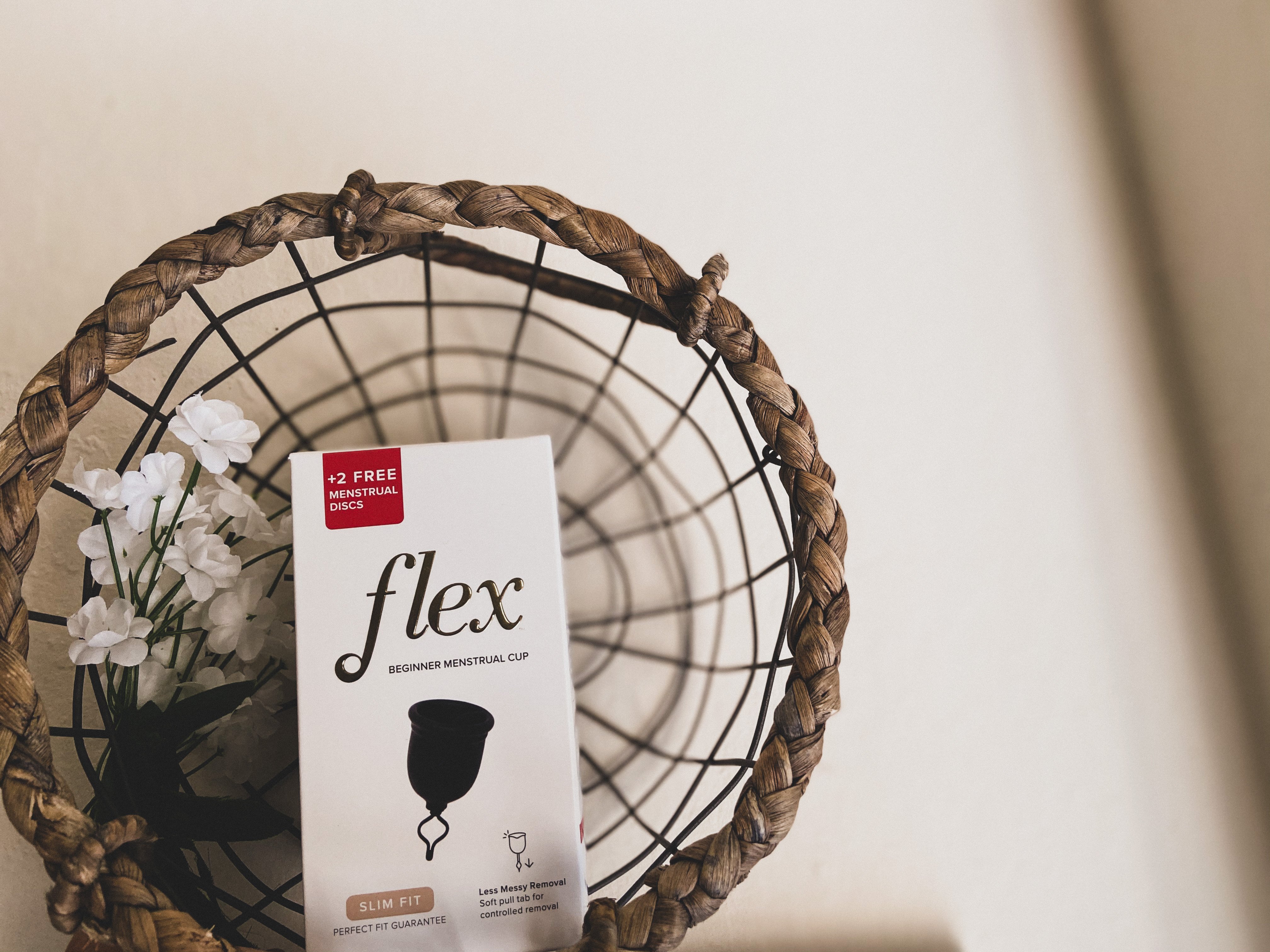 flex menstrual cup box in a basket with flowers