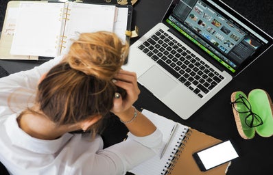 Stressed woman at desk with laptop