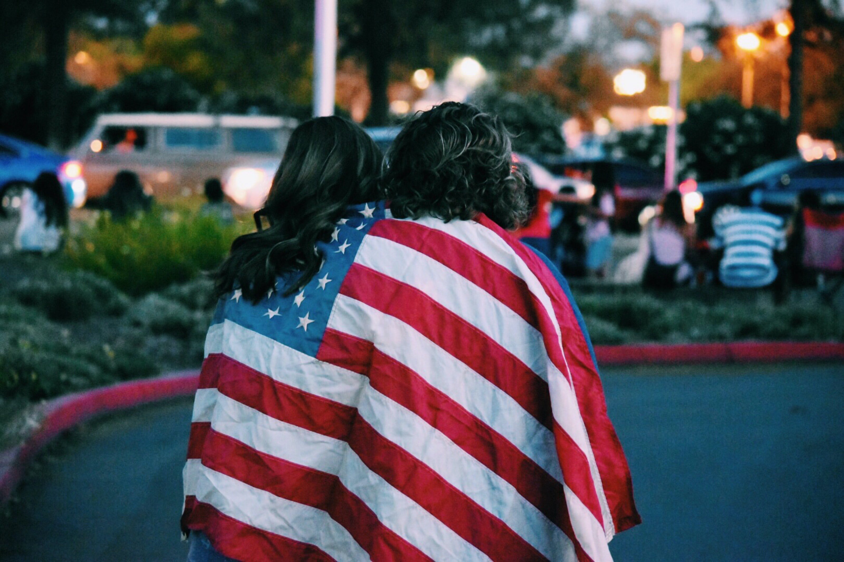 Two women wrapped in American flag
