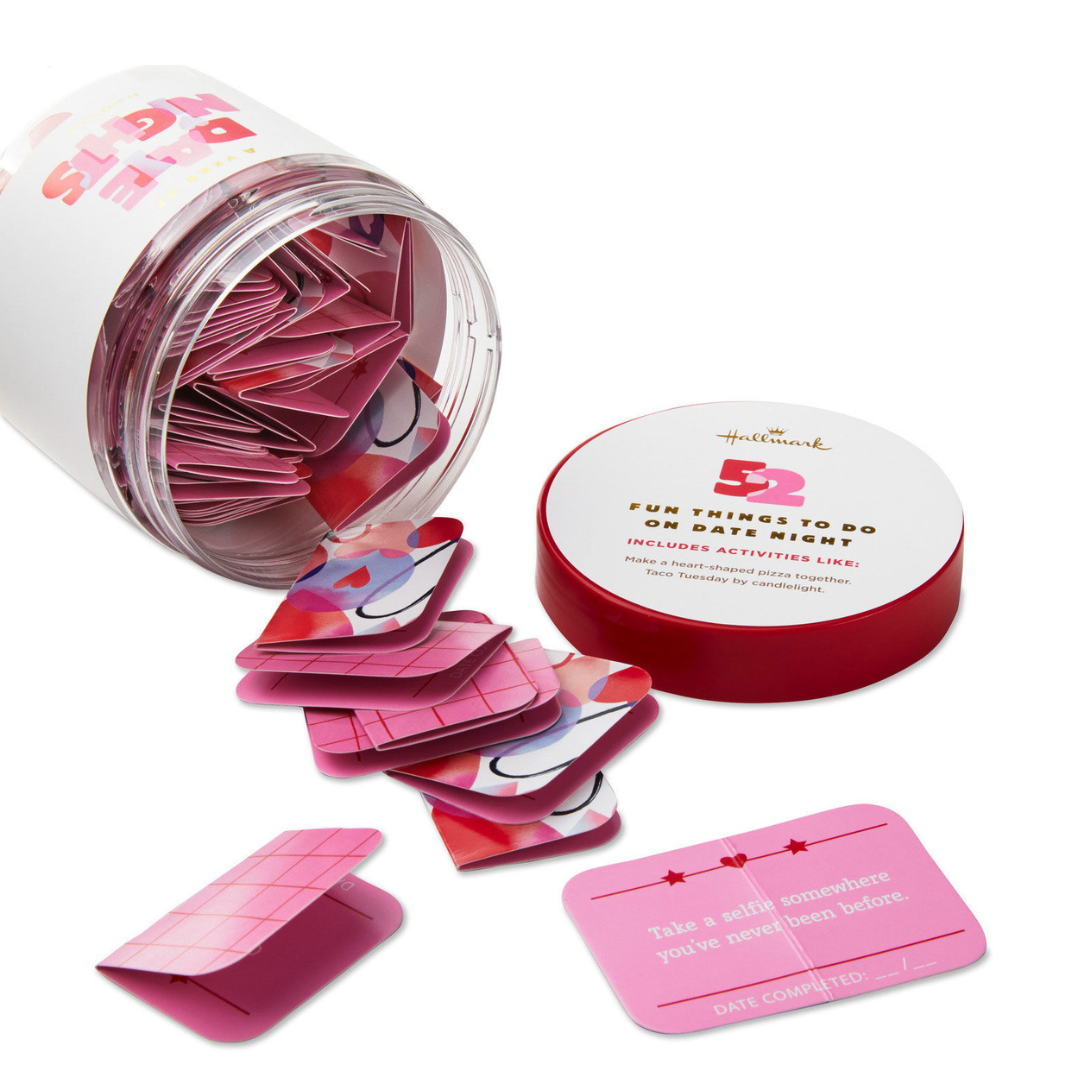 clear jar filled with pink and red cards containing date night ideas