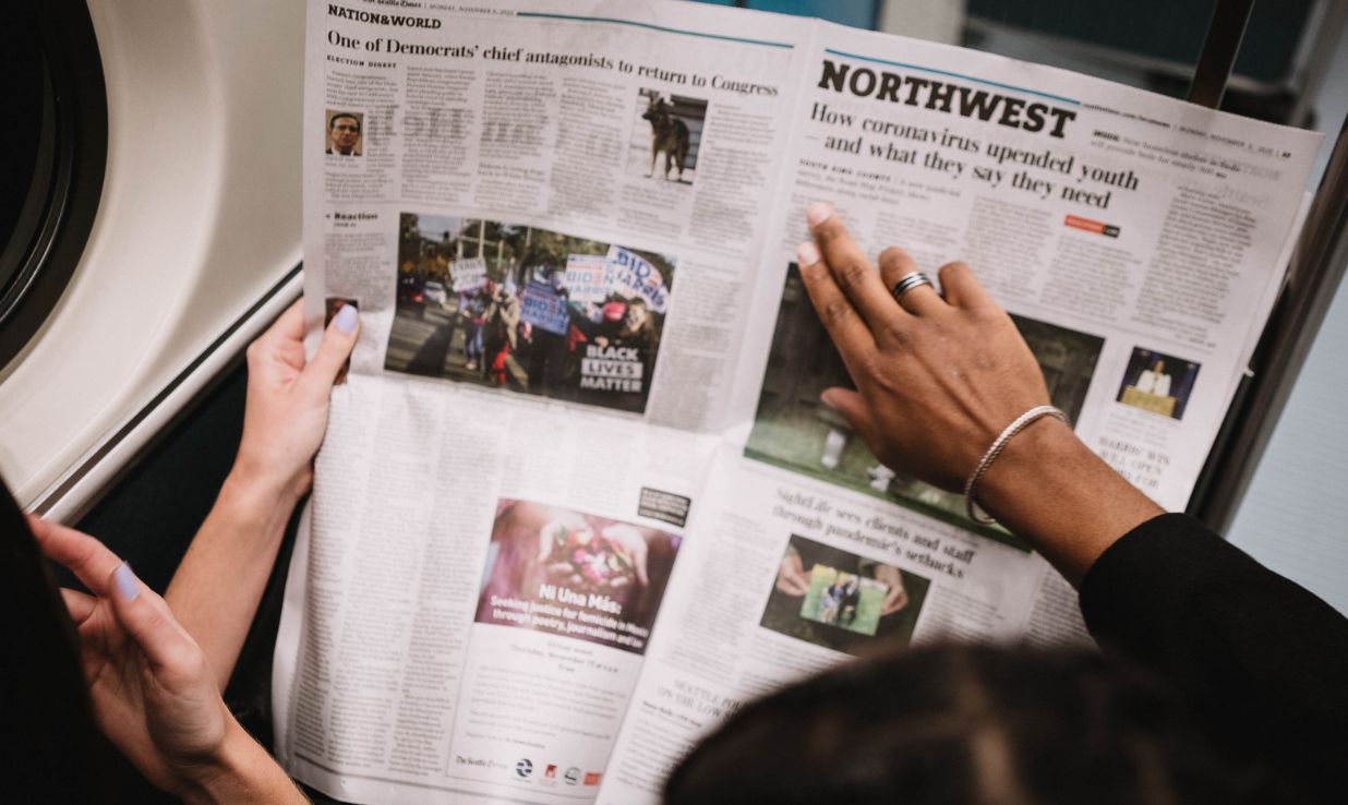 People reading the newspaper on a plane