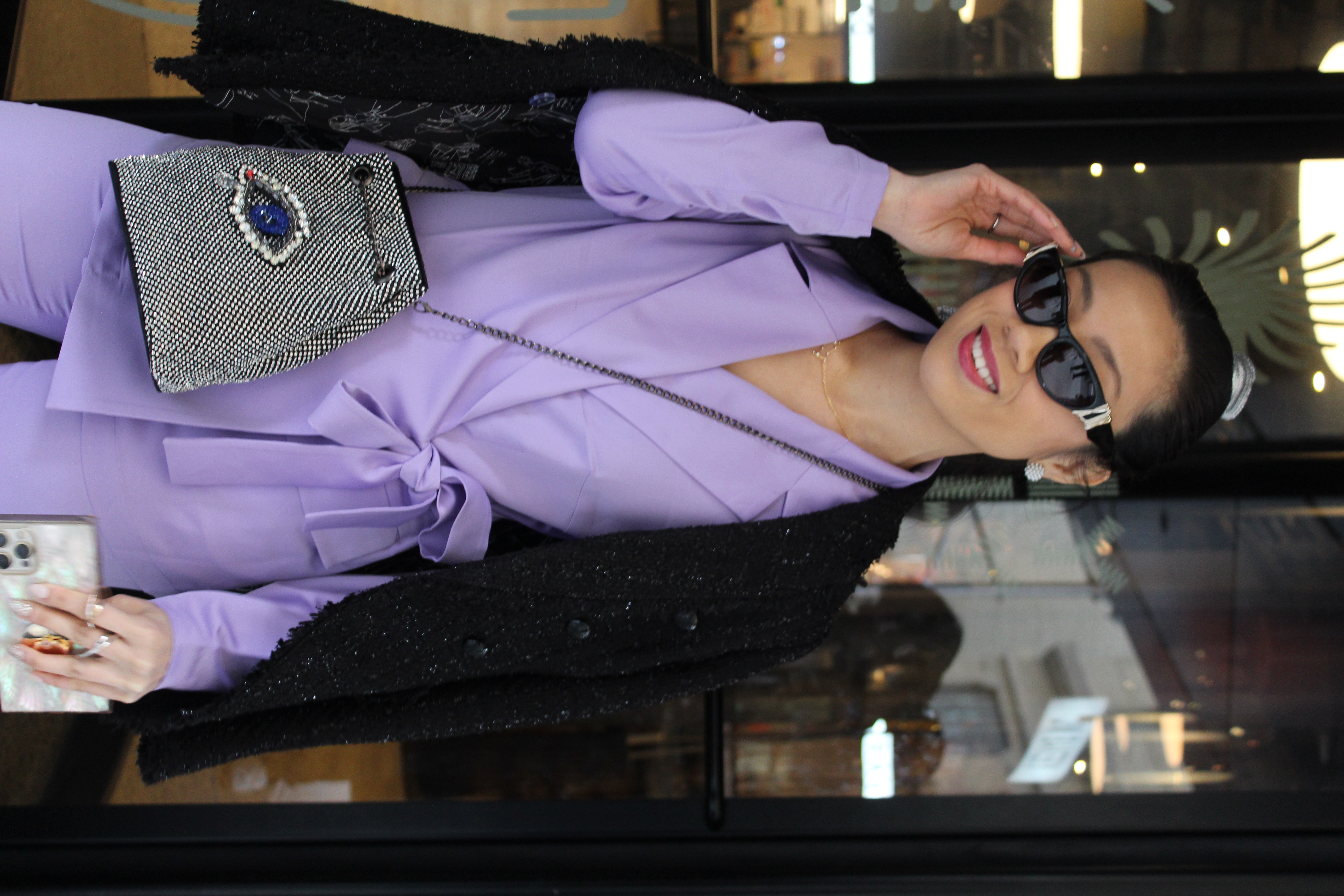Woman in purple suit holding her sunglasses
