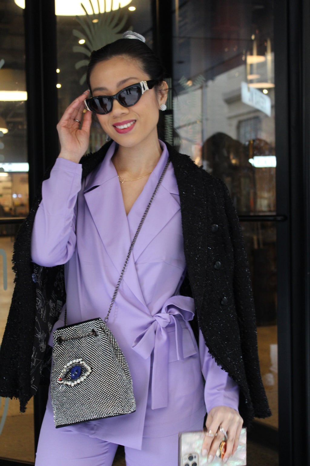 Woman in purple suit holding her sunglasses