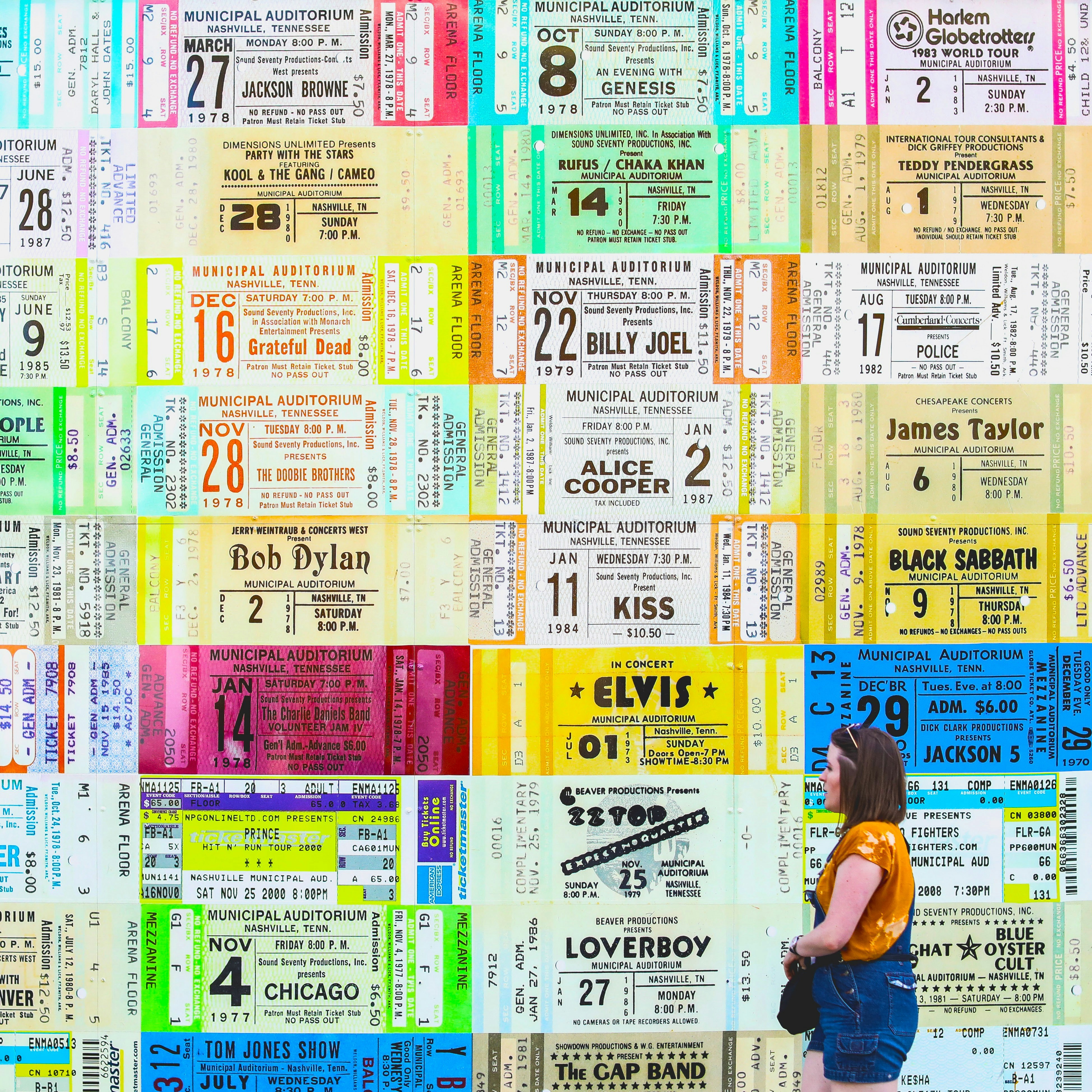 Women standing in front of a wall of tickets