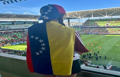 Picture of my back at a soccer stadium with a Venezuelan flag and cap