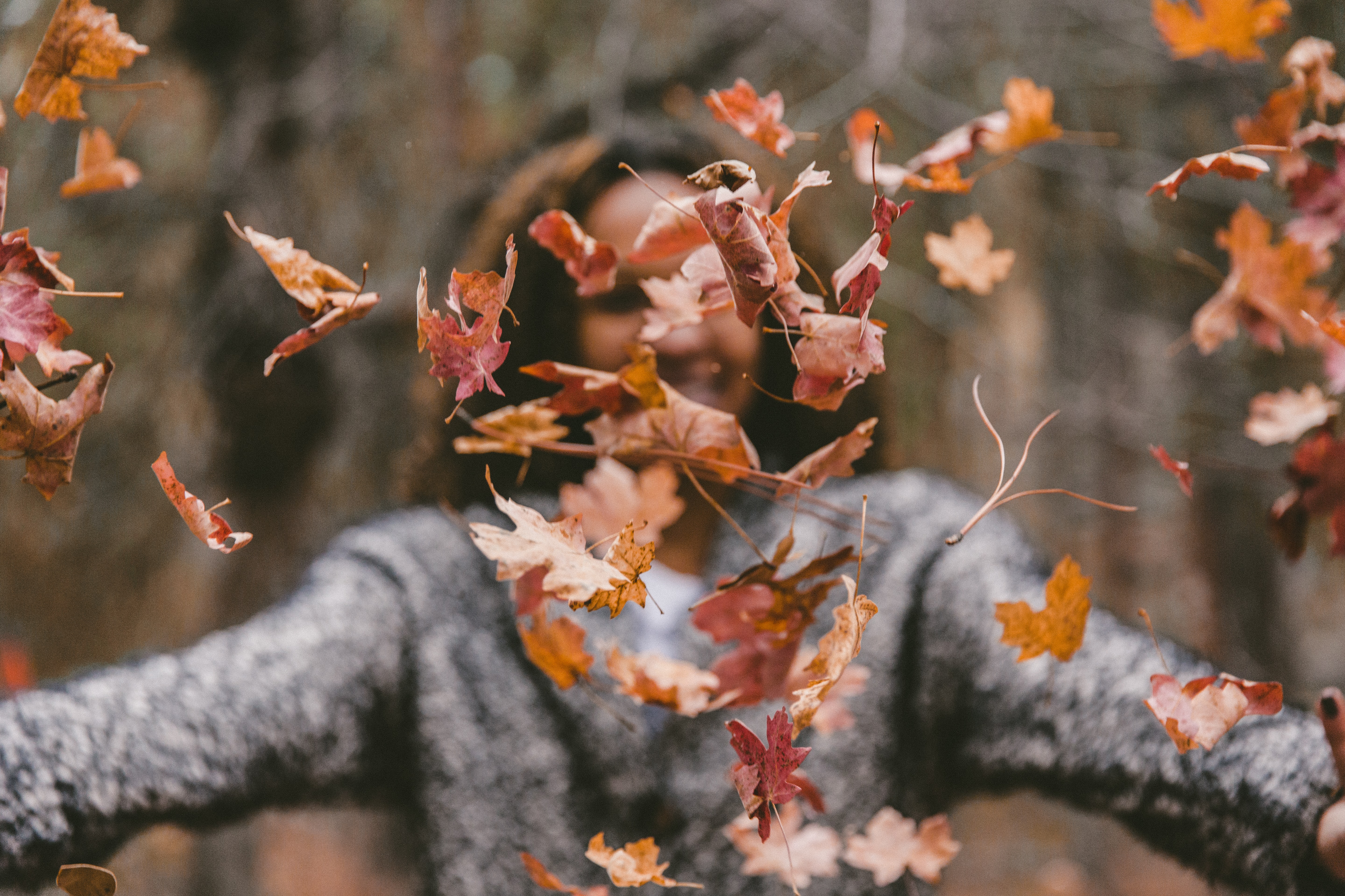 woman throwing leaves at camera