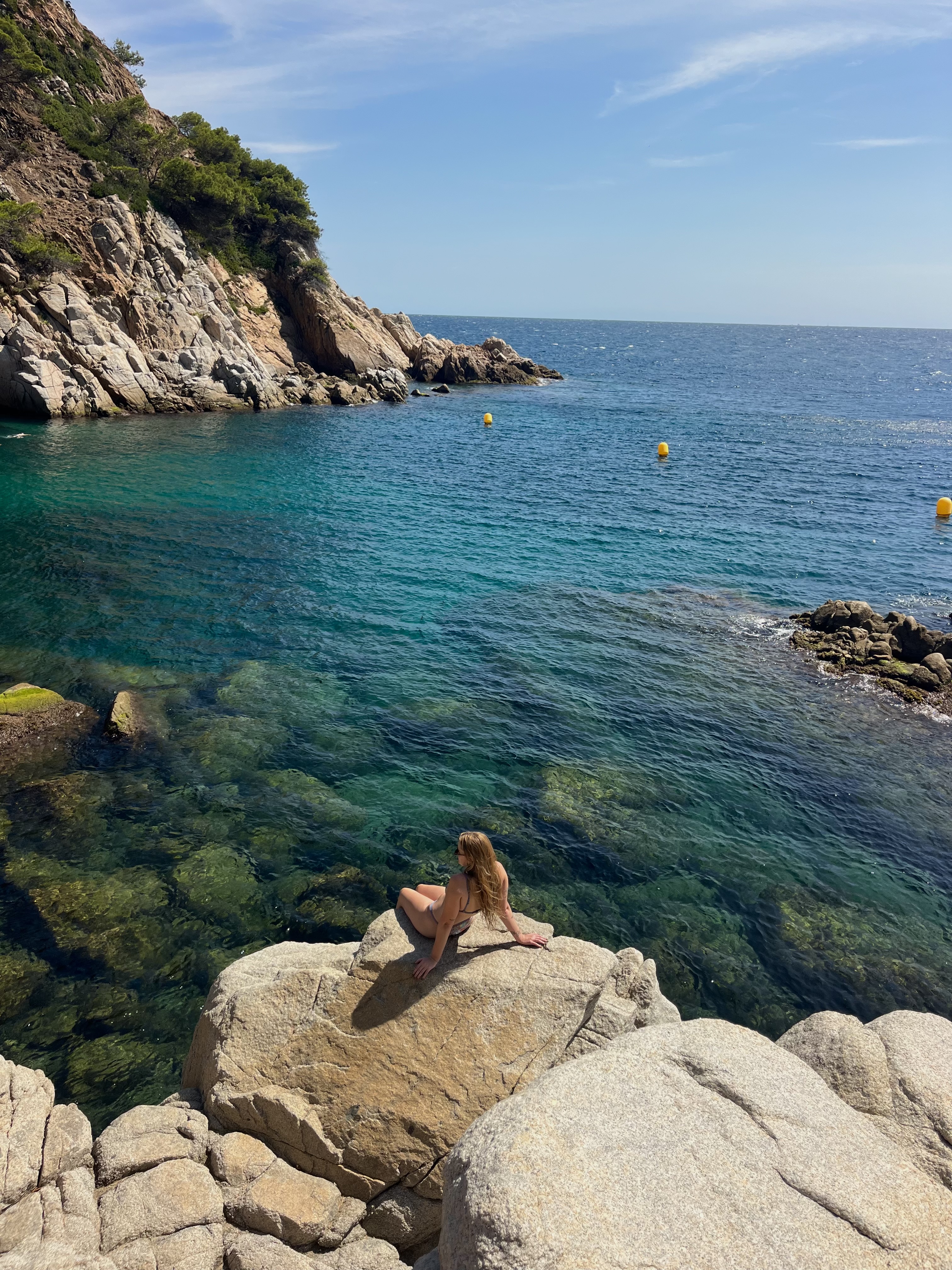 woman on rock in distance at the beach