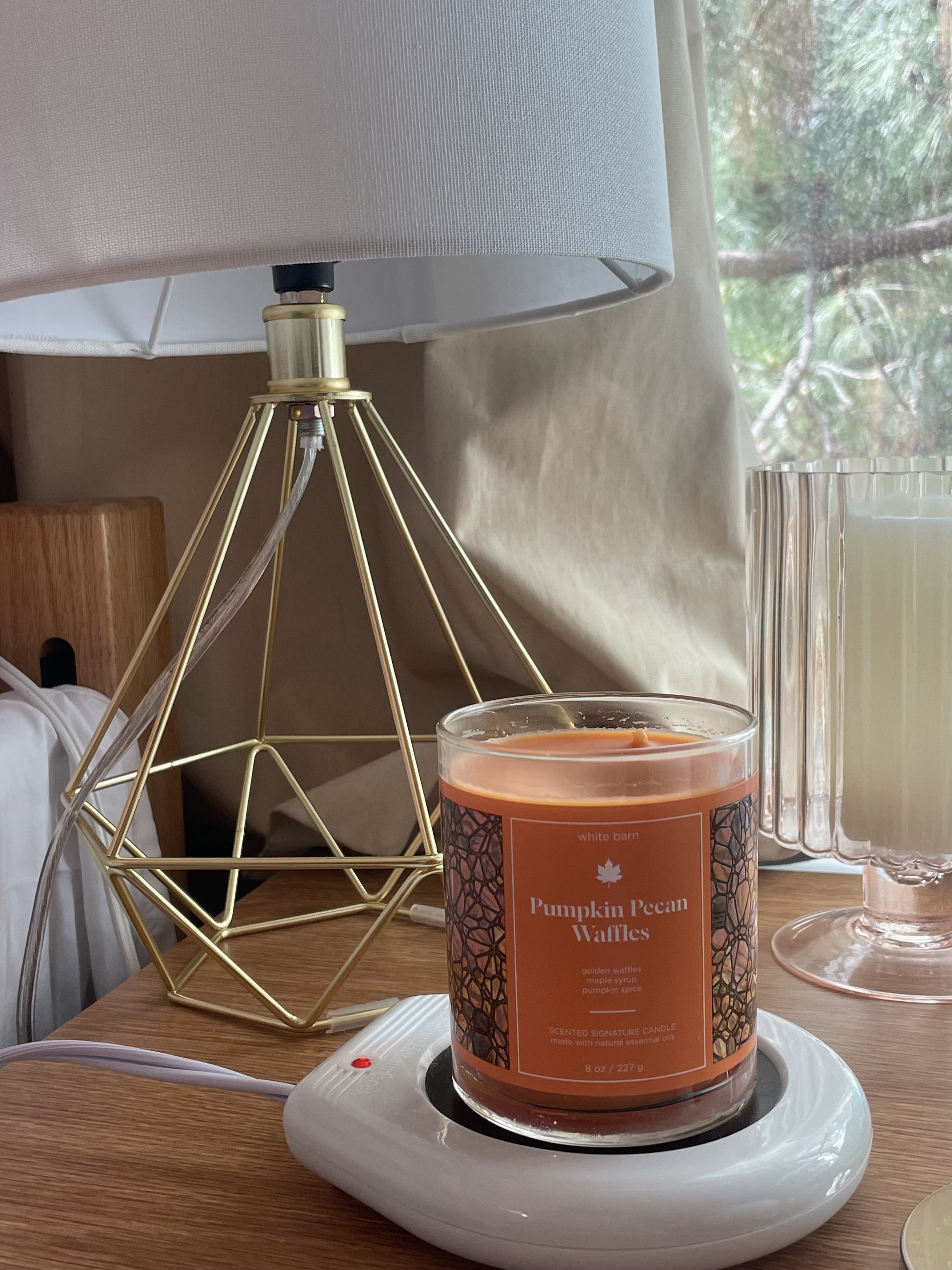 candles and a lamp on bed side table